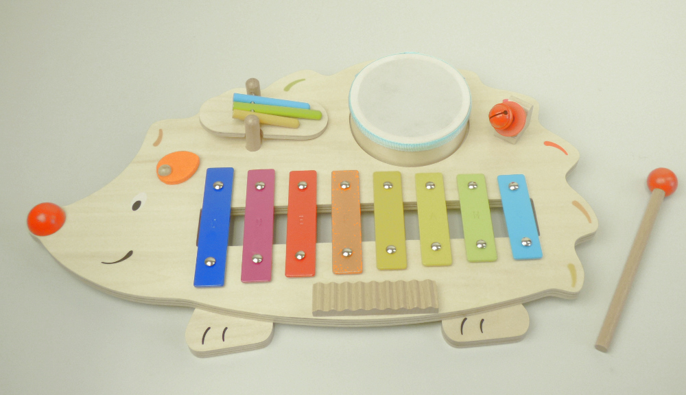 Bei dem durch ein Warenmuster veranschaulichten und als "Artikel 61883 - Musikstation Igel" betitelten Erzeugnis handelt es sich um ein Musikspielzeuginstrument in Form einer zusammengesetzten Ware, die im Wesentlichen von einem Glockenspiel (Metallophon) und einer integrierten Trommel gebildet wird.
Das Glockenspiel besteht aus acht unterschiedlich langen Metallplättchen (eine Oktave umfassend), die auf einem Rahmen aus Holz befestigt sind. Der Rahmen ist in Form eines Igels in den Abmessungen (L x B) von ca. 45 x 26 cm gestaltet. Auf dem Rahmen sind außerdem ein kleines „Riffelbrett“ aus Holz, eine sog. Schlagwippe aus Holz und eine Glocke aus unedlem Metall angebracht, mit denen ebenfalls Töne erzeugt werden können.
In einer runden Vertiefung im Rahmen befindet sich die Spielzeugtrommel, die herausgenommen werden kann. Da dem Glockenspiel lediglich ein Schlägel aus Holz beigefügt ist, handelt es sich nicht um ein Musikinstrument der Position 9206. Der Schlägel kann auch zum Schlagen der Trommel oder zur Tonerzeugung auf dem Riffelbrett verwendet werden.

Das Musikspielzeug bildet gemeinsam mit einem kleinen Notenheft eine Warenzusammenstellung, die gemeinsam in einem bedruckten Pappkarton für den Einzelverkauf aufgemacht ist.

Zolltarifrechtlich liegt ein "Musikspielzeuginstrument, nicht handgearbeitet aus Holz" vor.