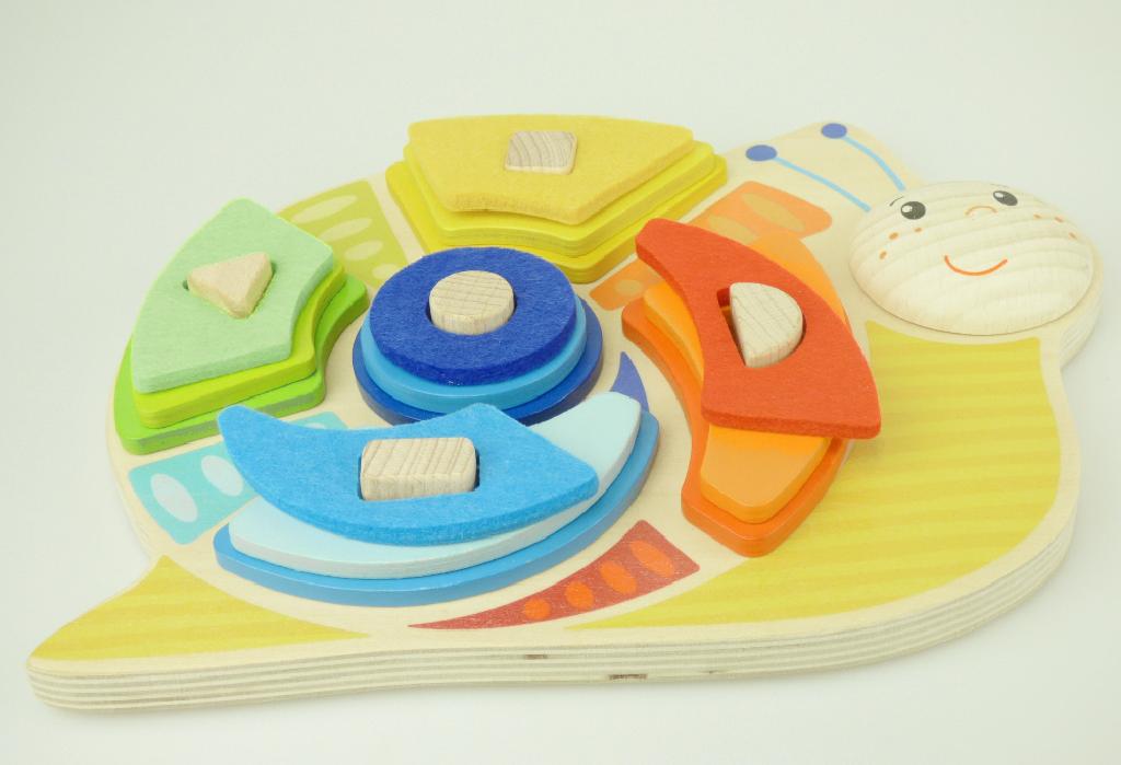 Bei dem sog. "Artikel 58399 - Sortierspiel Schnecke" handelt es sich um ein Puzzle in Form eines Steckspiels, bestehend aus
- einer ca. 24 x 17 x 1 cm großen Grundplatte in Form einer Schnecke aus Holz,
-- mit fünf senkrecht darauf angebrachten Holzstäben (ca. 2 cm hoch) in Form eines Dreiecks, eines
    Rechtecks, eines Halbkreises, eines Quadrates und eines Kreises,
- 15 farbigen Sortiersteinen in fünf Farben mit den Aussparungen in Form eines Dreiecks, eines
   Rechtecks, eines Halbkreises, eines Quadrates und eines Kreises
-- zehn Stück sind aus Holz gefertigt und fünf Stück aus Spinnstoff (Filz),
- die Sortiersteine sollen auf die der Form enstprechenden Stäbe gesteckt werden,
- ohne Hinweise auf Handarbeit,
- dient der spielerischen Unterhaltung
- in einem bunt bedruckten Pappkarton verpackt.

Derartige Erzeugnisse werden zolltarifrechtlich als "Puzzle, aus Holz, nicht handgearbeitet" eingereiht.