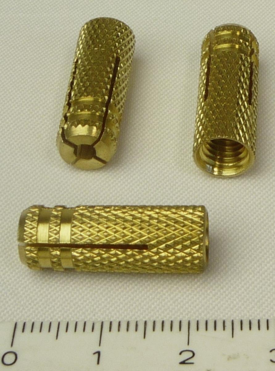 Sogenannter Spreizdübel, MS 6 / 10 K, Artikelnummer 26165

Es handelt sich um hohlzylindrische Erzeugnisse aus einer Kupfer-Zink-Legierung mit gewichtsmäßig vorherrschendem Kupfergehalt sowie mit einem Rautenmuster und an einem Ende mit zwei umlaufenden Nuten. Dasselbe Ende ist mit vier, kreuzförmig angeordneten Spreizschlitzen versehen. Die Erzeugnisse sind mit einem metrischen Innengewinde ausgestattet und werden an Schränken, Kellerregalen, Gardinenschienen etc. verwendet. Dazu werden sie in ein Bohrloch eingesteckt, durch Eindrehen der Schraube aufgespreizt und gegen die Bohrlochwand verspannt.
Sie weisen eine Gesamtlänge von ca. 22,5 mm auf und sind zu je 10 Stück aufgeblistert.
-Antragstellerangaben-
Abbildung siehe Anlage.
Derartige Erzeugnisse gehören als "Muttern aus Kupfer, mit Gewinde" zum TARIC-Code 7415 3300 00.
