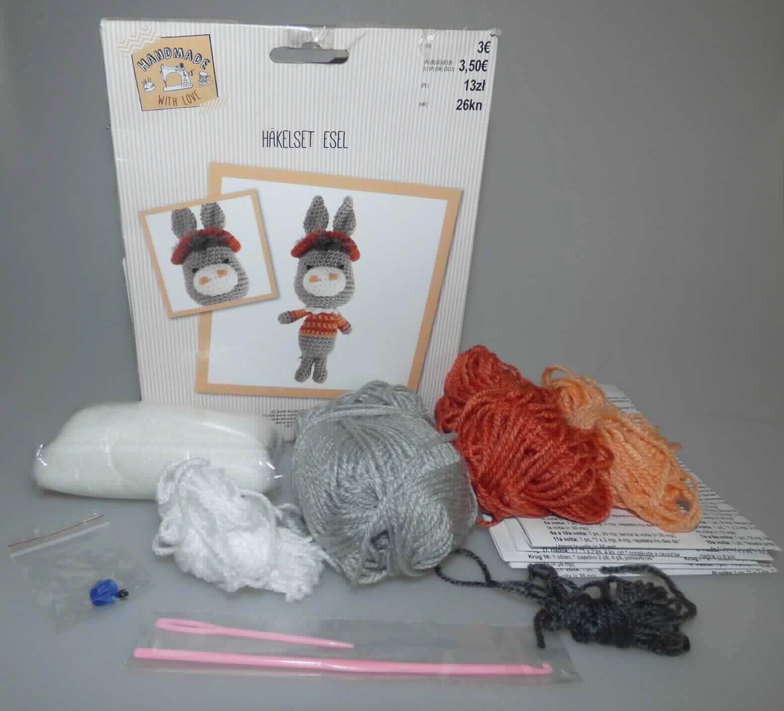 Häkel-Set, sog. Häkelset Esel, Art. 7770900353, Foto siehe Anlage,
- Warenzusammenstellung, bestehend aus fünf Garnen, einer Häkelnadel, einer Stopfnadel, Füllmaterial, 
  zwei Perlen, einem Pompon und fünf Anleitungen,
- gemeinsam in einer bedruckten Pappschachtel für den Einzelverkauf aufgemacht und zur Befriedigung eines 
  speziellen Bedarfs zusammengestellt,
- Garne, laut Untersuchungsergebnis:
-- aus synthetischen Spinnfasern (laut Antrag Polyacryl),
-- gezwirnt, mit einer S-Drehung als letzter Drehung,
-- im Knäuel (ohne Unterlage, u. a. deshalb kein Nähgarn),
-- mit einem Gewicht von nicht mehr als 500 g (Garn in Aufmachungen für den Einzelverkauf), u. a. somit keine 
   Ware der Position 5509,
-- mit einem Titer von ca. 3842 dtex, somit kein Bindfaden,
- Häkelnadel:
-- mit einer Länge von ca. 14 cm,
-- aus Kunststoff, 
- Stopfnadel:
-- mit einer Länge von ca. 7 cm,
-- aus Kunststoff, 
- Perlen:
-- aus Kunststoff,
-- mittig mit einem Loch ausgestattet und zum Annähen bestimmt,
- Füllmaterial:
-- aus losen synthetischen Spinnfasern,
- Pompon:
-- aus Spinnstoffen,
- Anleitungen:
-- in verschiedenen Sprachen aus Papier,
- keine Ware der Position 9503, da Häkeln als Handarbeit weder eine Freizeitbeschäftigung darstellt noch der
  spielerischen Unterhaltung von Kindern dient,
- die Garne bestimmen insbesondere im Hinblick auf die Bedeutung in Bezug auf die Verwendung den Charakter
  der Warenzusammenstellung.

"Garne aus synthetischen Spinnfasern, kein Nähgarn, in Aufmachungen für den Einzelverkauf, mit einem Anteil
 an synthetischen Spinnfasern von mehr als 85 GHT"