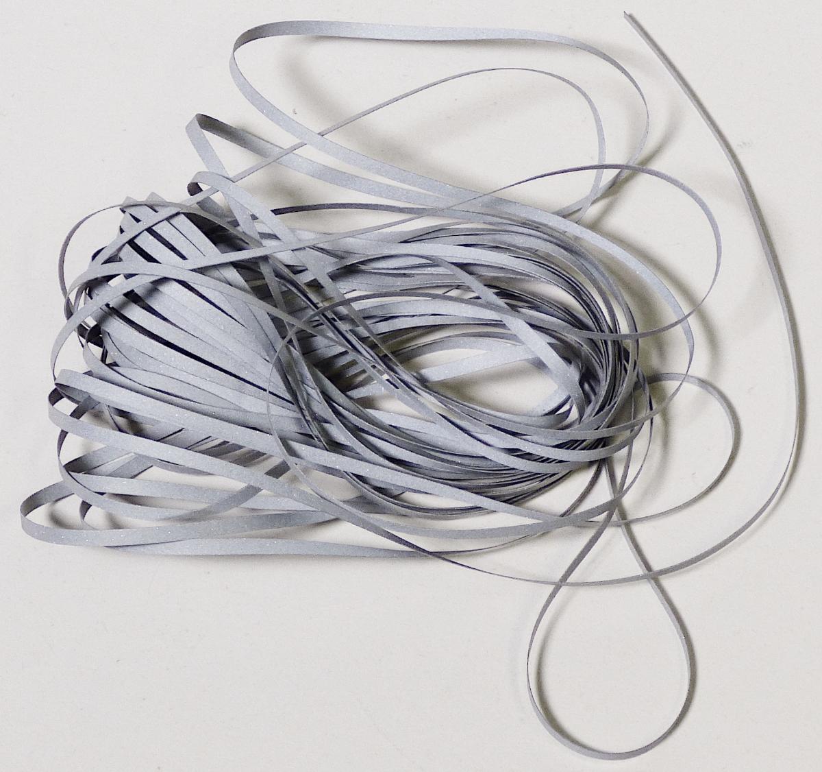 Überzogener Streifen der Position 5404, Foto siehe Anlage,
- als Meterware, 
- aus einem Streifen aus synthetischer Spinnmasse (laut Antrag Polyethylenterephthalat) mit einer 
  Breite von laut Antrag 2 mm (Streifen der Position 5404), 
- beidseitig mit dem bloßen Auge wahrnehmbar mit Kunststoff (Klebeschicht) überzogen und mit 
  metallisierten Glaskugeln versehen.

"Streifen der Position 5404, mit Kunststoff überzogen, aus synthetischer Spinnmasse"