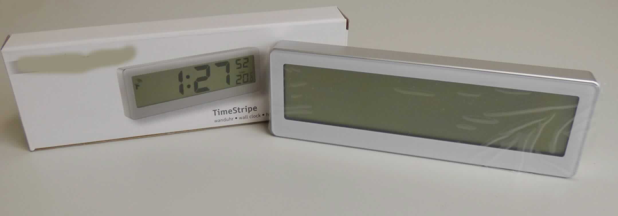 Bei der sog. "funkgesteuerten Designwanduhr", Art.-Nr. 929-00.002 handelt es sich um eine aus verschiedenen Bestandteilen zusammengesetzte Ware aus einem Thermometer für den Innenbereich und einer elektrisch betriebenen Wanduhr (Batterien enthalten), kein Kleinuhr-Werk enthaltend.

Eingefasst sind beide Bestandteile in einem ca. 21,5 x 7,2 x 2 cm (B x H x T) großen Kunststoffgehäuse, das auf der Rückseite mit vier Einstelltasten sowie einem Batteriefach versehen ist. 
Auf der Schauseite befindet sich ein ca. 19,5 x 4,5 cm (B x H) großes LCD-Display mit digitaler Anzeige. Zentral wird die Uhrzeit (Stunden, Minuten, Sekunden) in großen Ziffern angezeigt. Die Temperaturanzeige (Grad Celsius oder Fahreinheit) wird unten rechts in kleinen Ziffern angezeigt.

Die Uhr verleiht der Ware aufgrund des Umfangs und des Erscheinungsbildes ihren Charakter.

Die Ware ist mit einer Bedienungsanleitung in einem bedruckten Pappkarton aufgemacht.

Sie ist als "andere als von den Positionen 9101 bis 9104 erfasste Uhr, Wanduhr, elektrisch betrieben" einzureihen.