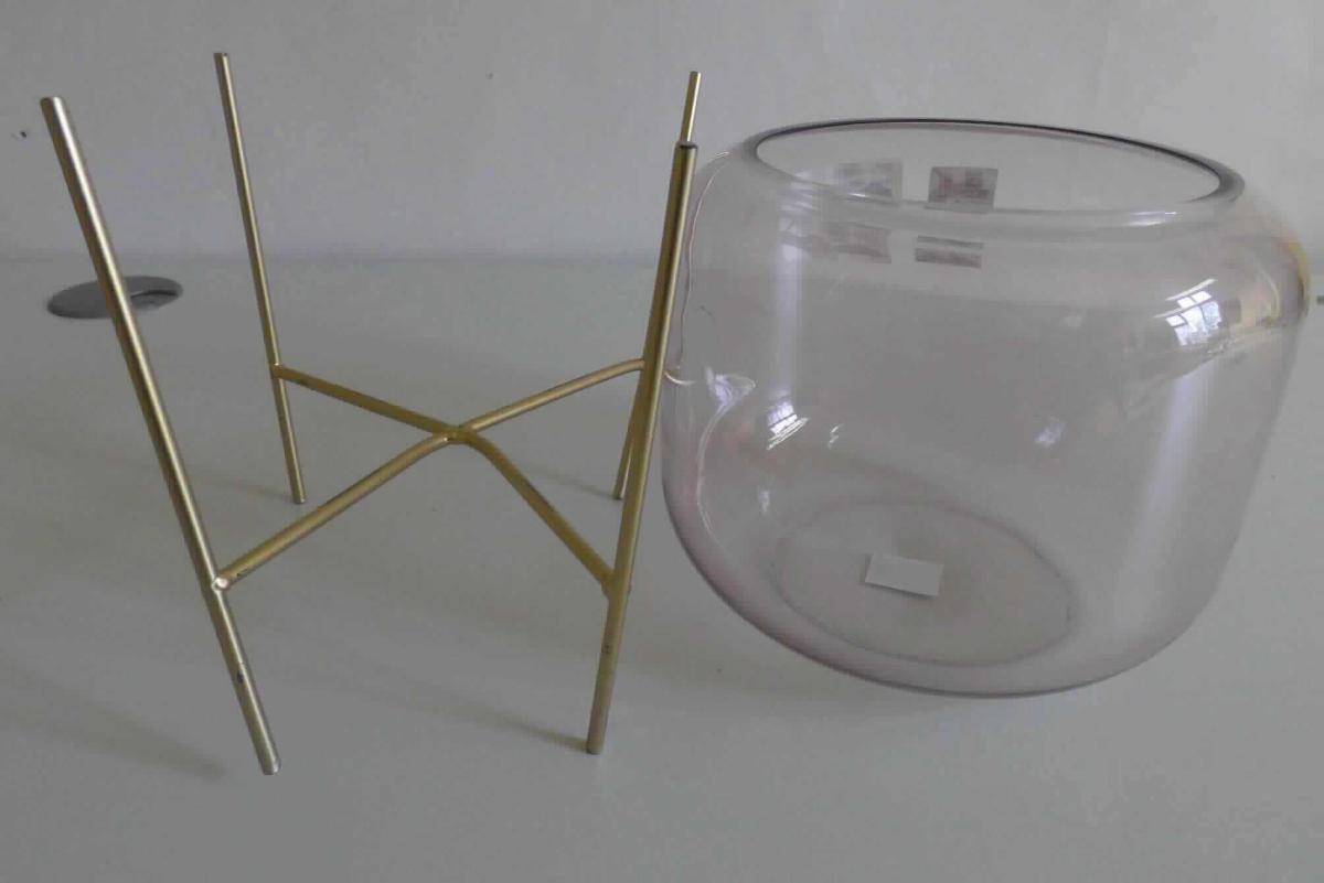 Glasware zur Innenausstattung, sog. Glas Objekt auf Metallfuß, 8319010-10, Foto siehe Anlage,
- bestehend aus einem Gefäß mit Halterung,
- Gefäß:
- - oben offen; am oberen Rand nach innen gearbeitet,
- - aus gewöhnlichem, handgefertigtem (laut Antrag mundgeblasenem) Glas,
- - in den Abmessungen: ca. 22 cm (Durchmesser) x 18 cm (Höhe),
- Halterung (sog. Metallfuß):
- - aus unedlem Metall; messingfarben,
- - mit vier Beinen; in der Mitte kreuzförmig gearbeitet,
- im Hinblick auf den Umfang und die Verwendung (z. B. Aufnahme dekorativer Gegenstände oder 
  einer Kerze) bestimmt das Gefäß den wesentlichen Charakter der Ware.

"Glasware zur Innenausstattung, aus gewöhnlichem Glas, handgefertigt"