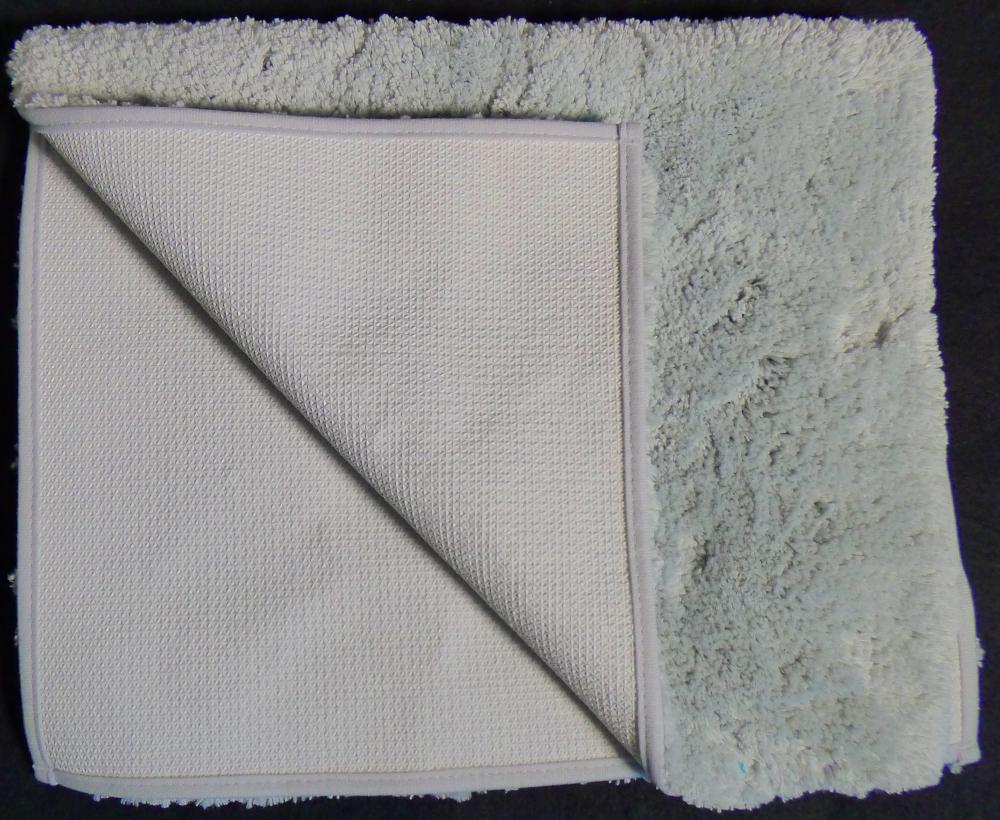 Fußbodenbelag (Badematte), sog. Badteppich Chenille (hell)grau, Art. NAN 9894811, Foto siehe 
Anlage,
- laut Antrag in verschiedenen Farbvarianten,
- rechteckig, in den Abmessungen von laut Antrag 50 cm x 80 cm,
- aus synthetischen Spinnstoffen (laut Antrag 100 % Polyester),
- getuftet (Nadelflor),
- mit einem Grund aus einem Gewebe und einem nachträglich in den Grund eingezogenen Flor
  aus Garnen,
- an den Rändern mit schmalen Gewirkestreifen eingefasst (somit konfektioniert und u. a. 
  keine Fliese),
- auf der Rückseite rutschhemmend ausgerüstet,
- erfüllt die Bedingungen zur Einreihung als Fußbodenbelag.

"Fußbodenbelag (Badematte), aus Spinnstoffen, getuftet (Nadelflor), konfektioniert, aus 
 synthetischen Spinnstoffen (Polyester), keine Fliese"