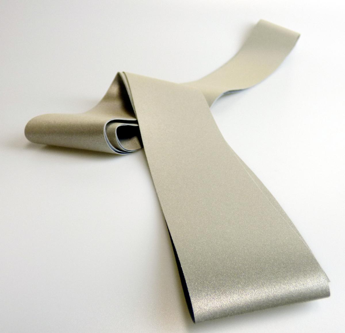 Überzogenes Gewebe, sog. Reflexband, Foto siehe Anlage,
- als Meterware, mit einer Breite von ca. 5,1 cm,
- aus einem Gewebe aus Spinnstoffen,
- mit einer reflektierenden Schicht; bestrichen mit Klebstoff und flächendeckend überdeckt mit nicht
  vollständig eingebetteten, metalisierten Mikro-Glaskugeln (mit einem Durchmesser von weniger als
  150 µm),
- das Überziehen ist mit dem bloßen Auge wahrnehmbar.

"Überzogenes Gewebe, anderes als in den Positionen 5901 bis 5906 genannte, beschichtet mit in 
 Klebstoff eingebetteten Kügelchen mit einem Durchmesser von nicht mehr als 150 µm"