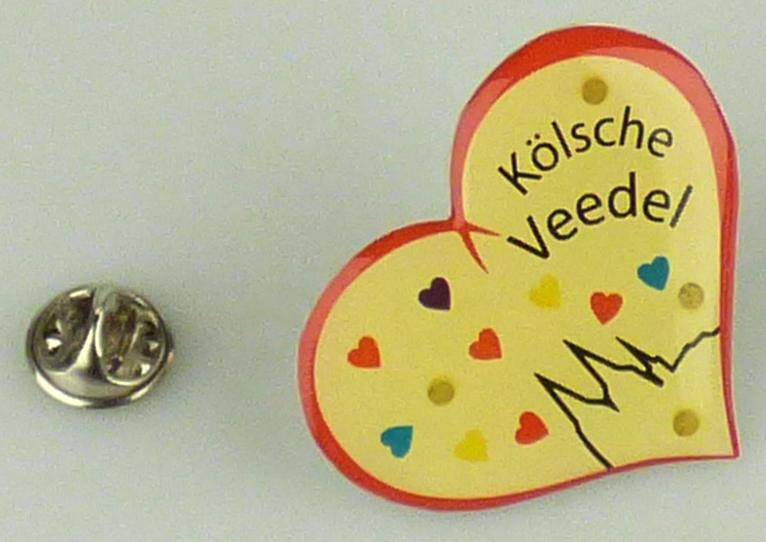 Es handelt sich um Anstecker (sog. LED-Anstecker "Blinki") mit einer herzförmigen Platte aus Kunststoffen, die auf der Schauseite mit drei batteriebetriebenen Leuchtdioden und mit Bildmotiven und Schriftzügen versehen sind. An der Rückseite der Platte sind ein rundes, aufschraubbares Gehäuse aus unedlen Metallen mit zwei eingesetzten Knopfzellen und ein Schmetterlingsverschluss aus unedlen Metallen zur Befestigung an der Kleidung angebracht. Die Erzeugnisse sind auf einer Pappkarte befestigt und in einer durchsichtigen Folientüte verpackt.

Bei den aus verschiedenen Bestandteilen zusammengesetzten Waren bestimmt der Anstecker insbesondere im Hinblick auf den Umfang und die Bedeutung für die Verwendung den Charakter der Ware. Innerhalb der aus verschiedenen Stoffen zusammengesetzten Anstecker sind die nicht metallischen Stoffe hinsichtlich der Bedeutung für die Verwendung (Zierwirkung) charakterverleihend.

Abbildung siehe Anlage.

Derartige Erzeugnisse gehören als "Fantasieschmuck, anderer als aus unedlen Metallen" zur Codenummer 7117 9000 00 0 des Zolltarifs.