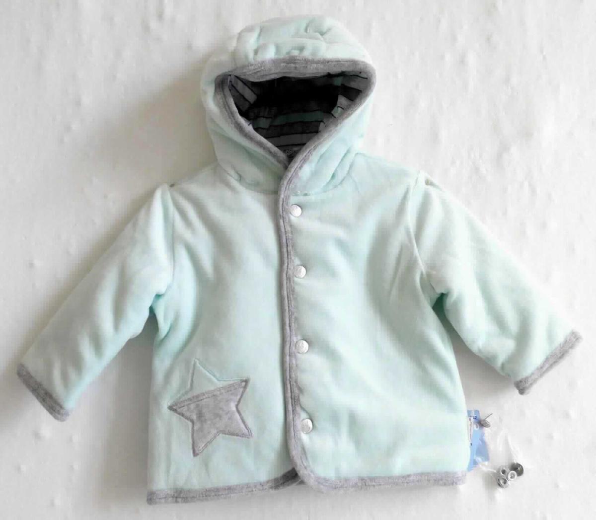 Kleidung für Kleinkinder, sog. Kapuzenjacke aus Wirkware, Art. 5611735, für Kleinkinder im Alter von 4-5 Monaten (entspricht Größe 62 bis 68), Foto siehe Anlage,
- zusammen mit zwei, in einem angehefteten Kunststofftütchen verpackten Ersatzdruckknöpfen auf einem 
  Kleiderbügel hängend in einem Polybeutel verpackt, die Ersatzdruckknöpfe für das Kleidungsstück sind gering-
  wertig und im Hinblick auf die Verwendung als unbedeutend zu betrachten, sie ändern das Wesen der Hauptware 
  nicht und sind deshalb wie diese einzureihen,
- aus ca. 1,2 mm dicken, einfarbigen Samtgewirken aus laut Antrag 76 % Baumwolle und 24 % Polyester
  (synthetische Chemiefasern), 
- wattiert gefüttert,
- über die Taille reichend (Rückenlänge: ca. 31 cm),
- mit einer angesetzten Kapuze,
- vorn mit einer durchgehenden Öffnung mit einem Druckknopfverschluss von links über rechts,
- mit langen Ärmeln,
- auf der rechten Seite in Taillenhöhe mit einem aufgestickten Stern verziert,
- an allen Rändern mit schmalen Streifen aus konstrastfarbenen Samtgewirken eingefasst, 
- für Kleinkinder mit einer Körpergröße von bis zu 86 cm bestimmt.

"Kleidung für Kleinkinder, aus Gewirken, aus Baumwolle"