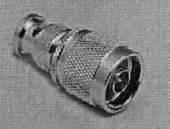 Adapter (BNC-Stecker auf N-Stecker)
- im Wesentlichen bestehend aus einem spezifisch geformten Metallgehäuse (Gesamtlänge 37,5 mm) 
  mit Mehrfach-Rändelung, 
- mit einer Steckvorrichtung in Form eines BNC-Steckers (koaxialer Steckverbinder mit einem 
  Bajonettverschluss) auf der einen Seite und 
  einem N-Stecker (koaxialer Steckverbinder mit Schraubverriegelung) auf der anderen Seite, 
- zur Koaxialkabelmontage,
- als HF-Steckverbindung,
- mit Delrin-Isolation,
- für eine Impedanz von 50 Ohm ausgelegt,
- für eine Spannung von weniger als 1000 Volt konzipiert,
- zum Herstellen einer elektrischen Steckverbindung mit einem entsprechenden Gegenkontakt.

Die Ware ist als "elektrisches Gerät zum Verbinden von elektrischen Stromkreisen, für eine Spannung von 1000 V oder weniger, Steckvorrichtung für Koaxialkabel" einzureihen.

Anlage: 1 Abbildung