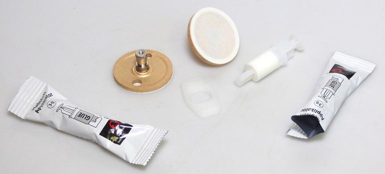 Es handelt sich um eine Warenzusammenstellung in Aufmachung für den Einzelverkauf, bestehend aus:
- zwei Adaptern mit runder Grundplatte (Durchmesser ca. 3,9 cm und Stärke ca. 0,3 cm) aus einer Kupferlegierung mit gewichtsmäßig vorherrschendem Kupfergehalt und einem Bolzen aus Stahl (Höhe ca. 1,7 cm und maximaler Durchmesser ca. 0,8 cm), die auf der Rückseite mit einem ringförmigen Klebepad aus PE-Schaum versehen sind,
- zwei spritzenförmige Spender mit Klebstoff,
- einer sechseckigen Platte aus Kunststoff mit einer mittigen, kreisrunden Lochung, die als Ausdrückhilfe für die o. g. spritzenförmigen Spender mit Klebstoff dient und
- einer Anleitung zur Anbringung der Adapter.
Die o. g. Bestandteile befinden sich zur Abgabe an Endkunden in einer gemeinsamen und produktspezifisch bedruckten Umverpackung aus Pappe.
Diese Zusammenstellung dient der Befestigung von Waren (z. B. Badezimmerartikel) an Wänden.
- Angaben laut Antragstellerin -

Die Adapter bestimmen im Hinblick auf die Bedeutung für die Verwendung den Charakter der Warenzusammenstellung. Bei den aus verschiedenen Stoffen zusammengesetzten Adaptern sind die unedlen Metalle hinsichtlich der Bedeutung für die Verwendung und des Umfanges charakterbestimmend. 
Kupfer herrscht gegenüber jedem anderen unedlen Metall gewichtsmäßig vor.
 
Abbildung siehe Anlage.

Derartige Erzeugnisse gehören als "andere (als in den TARIC-Codes 7419 2000 10 bis 7419 8090 91 genannte) Waren aus Kupfer" zum TARIC-Code 7419 8090 98.