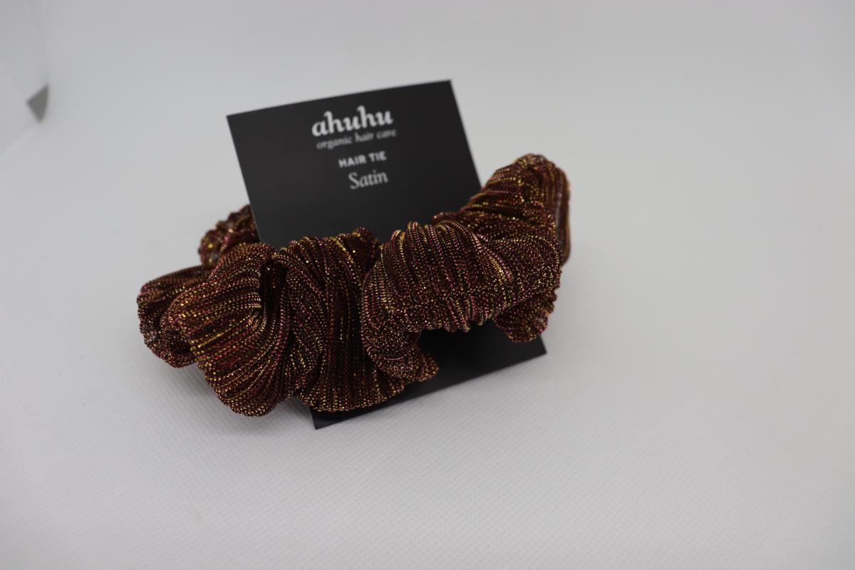 Haargummi, sog. Scrunchie- haargummi aus Spinnstoff, Foto siehe Anlage,
- an einer bedruckten Pappkarte befestigt,
- flachliegend mit einem Außendurchmesser von ca. 12 cm,
- aus ca. 0,4 mm dicken, buntgewirkten Gewirken aus laut Antrag 87 % Polyester und 13 % Elasthan
  (beides synthetische Chemiefasern),
- ein elastisches Band enthaltend und dadurch gerafft,
- durch schlauch- und ringförmiges Zusammennähen konfektioniert,
- wird zum Zusammenhalten des Haares und zugleich als Kopf-/Haarschmuck getragen,
- in Anbetracht des textilen Charakters wird die Ware nicht vom Warenkreis der Position 9615 erfasst,
- individuelles (selbstständiges) Einzelstück, das eine Ergänzung von Kleidung darstellt, somit keine Ware
  der Position 6307.

"Anderes konfektioniertes Bekleidungszubehör (Haargummi), aus elastischen Gewirken"