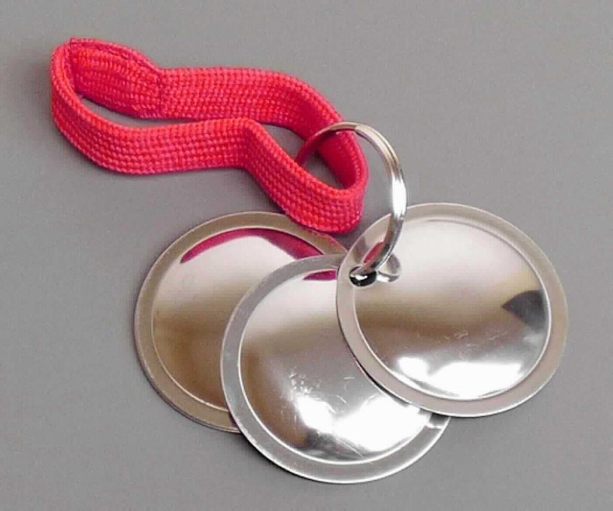 Es handelt sich um sog. Trainer-Discs, bestehend aus einem Schlüsselring aus unedlem Metall, an dem fünf runde, gewölbte Plättchen mit abgeflachtem Rand aus unedlem Metall (Durchmesser: etwa 4,5 cm), die am Rand eine Lochung aufweisen, befestigt sind. An dem Schlüsselring ist zudem eine etwa 8 cm lange, elastische Schlaufe aus einem gewebten Spinnstoffband angebracht. Das Erzeugnis wird bei der spielerischen Erziehung und Ausbildung von Hunden nach der Signalton-Methode eingesetzt. Hierzu wird die Ware entweder geworfen oder in der Hand gehalten und bewegt. Hierbei schlagen die Plättchen aneinander und erzeugen einen Ton in der Art von Schellengeräuschen. Die Ware ist mit einer Trainingsanleitung auf einer Pappkarte mit Blisterverpackung für den Einzelverkauf aufgemacht.

Abbildung siehe Anlage.

Derartige Erzeugnisse gehören als "den Glocken, Klingeln und Gongs ähnliche Waren, nicht elektrisch, aus unedlen Metallen" zur Codenummer 8306 1000 00 0 des Zolltarifs.