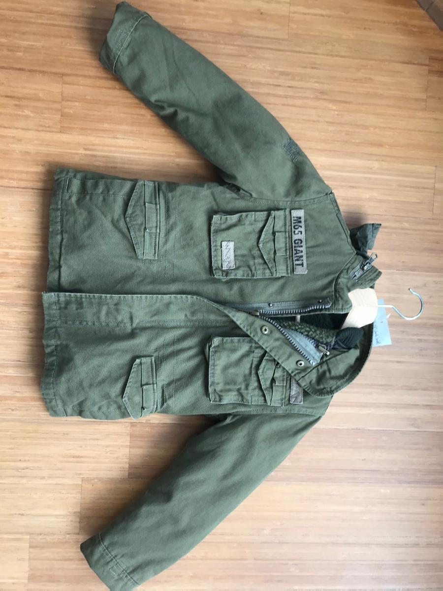 Zwei miteinander verbundene Kleidungsstücke, bestehend aus einem Anorak (Außenteil) und einem
anorakähnlichen Kleidungsstück (Innenteil), sog. M65 Giant Kids, Art. 6013, Größe 122/128, Foto
siehe Anlage,
- in einem Polybeutel verpackt,
- die Kleidungsstücke sind durch Reiß- und Druckknopfverschlüsse miteinander verbunden, können
  aber auch separat getragen werden,
- Anorak:
-- aus ca. 0,5 mm dicken, einfarbigen Geweben aus laut Antrag 100 % Baumwolle,
-- durchgehend gefüttert,
-- über den Schritt reichend (Rückenlänge: ca. 51 cm),
-- mit einem Stehkragen mit einer in den Kragen einrollbaren Kapuze mit Tunnelzug,
-- vorn mit einer durchgehenden Öffnung mit Reißverschluss und einer überlappenden Patte mit
   Druckknopfverschluss von links über rechts (Knabenkleidung),
-- mit langen Ärmeln; an den Ärmelenden mit einem Klettverschlussriegel zu verengen,
-- mit verschiedenen ein- und aufgesetzten Taschen,
-- am unteren Rand durch Umschlagen und Festnähen gesäumt,
-- wird im Allgemeinen über jeder anderen Kleidung und zum Schutz gegen das Wetter getragen,
   somit keine Jacke.

"Anorak, aus Geweben, für Knaben, aus Baumwolle, nicht nach dem Batik-Verfahren handbedruckt"