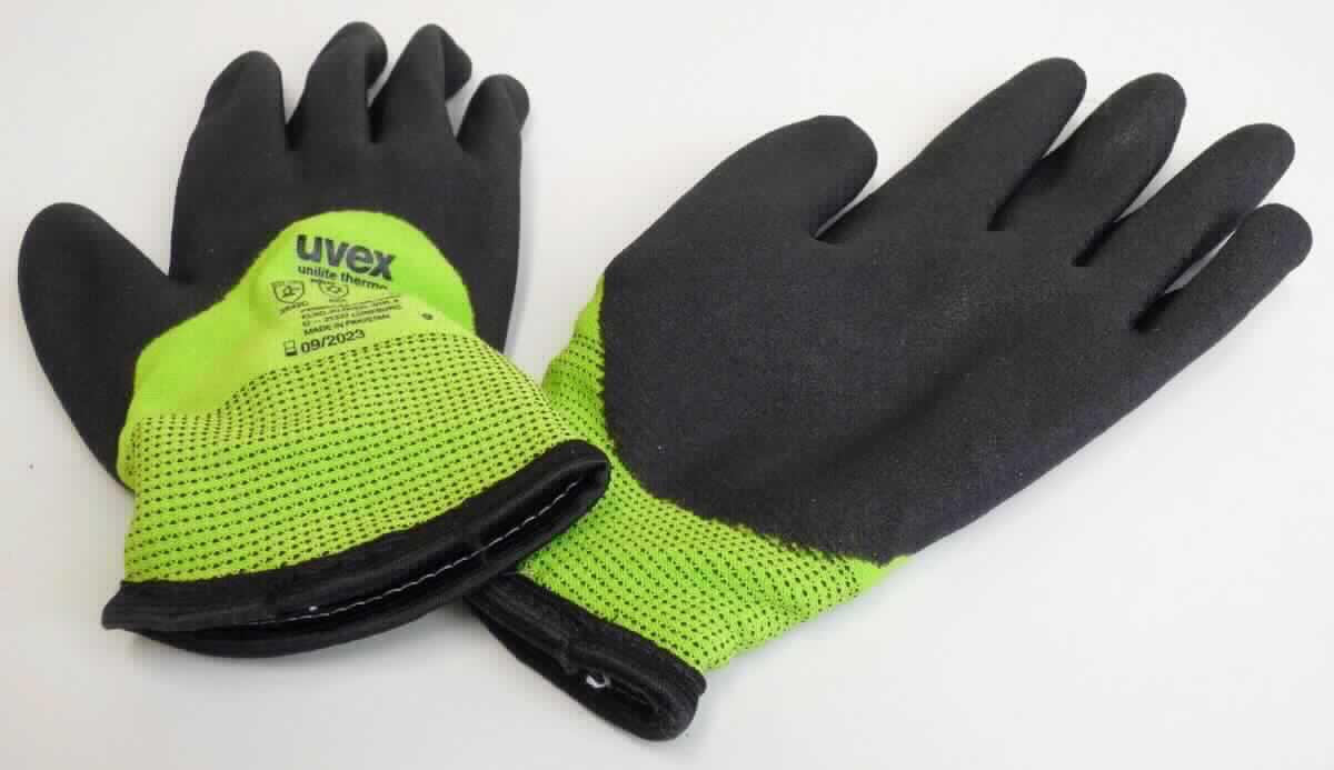 Fingerhandschuhe, sog. Arbeitsschutzhandschuhe uvex unilite thermo plus cut c, in Erwachsenengröße, Foto 
siehe Anlage,
- als Fünffingerhandschuhe gearbeitet,
- aus buntgewirkten Gewirken aus laut Antrag 70 % Nylon (synthetische Chemiefasern) und 30 % Glasfasern,
- nachträglich mit Ausnahme des größten Teils der Stulpe sowie Teilen des Handrückens einseitig (Außenseite) 
  im Tauchverfahren mit Kunststoff (laut Antrag PVC = Polyvinylchlorid; keine Zellstruktur erkennbar) überzogen,
- durchgehend gefüttert,
- auf dem Handrücken bedruckt,
- am unteren Rand mit einer schmalen Einfassung aus Gewirken versehen,
- insbesondere im Hinblick auf die gewichtsmäßige Zusammensetzung bestimmen die Spinnstoffe gegenüber den
  Glasfasern den Charakter der Ware.

"Fingerhandschuhe, aus Gewirken, mit Kunststoff überzogen"