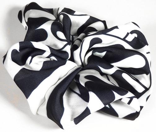 Haargummi, Foto siehe Anlage,
- in flachliegendem Zustand mit einem Außendurchmesser von ca. 13 cm,
- aus bedruckten Geweben aus laut Antrag 100 % Polyester (synthetische Chemiefasern),
- ein elastisches Band enthaltend und dadurch gerafft,
- durch schlauch- und ringförmiges Zusammennähen konfektioniert,
- ohne Hinweise auf Handarbeit,
- wird zum Zusammenhalten des Haares getragen,
- in Anbetracht des textilen Charakters wird die Ware nicht vom Warenkreis der Position 9615 erfasst,
- individuelles (selbstständiges) Einzelstück, das eine Ergänzung von Kleidung darstellt.

"Anderes konfektioniertes Bekleidungszubehör (Haargummi), aus Spinnstoffen, aus Geweben, nicht
 handgearbeitet"
