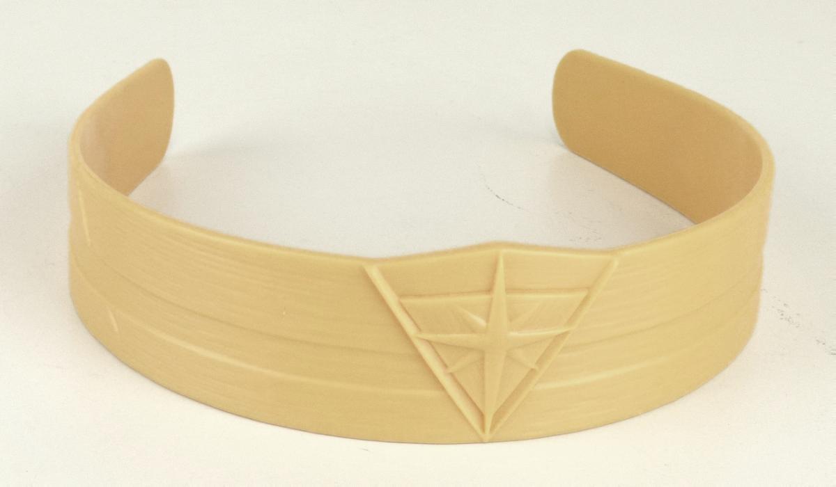 Es handelt sich um einen Haarreif, der aus einem ca. 12,5 cm breiten, gebogenen, der Kopfform angepassten, an den Enden offenen Reif aus gelben Kunststoff besteht, der auf der Schauseite mit einem Stern versehen ist.

Die in einer Kunststofftüte verpackte Ware wird zum Zusammen- bzw. Zurückhalten des Haares und zugleich als dekorativer Schmuck verwendet.

Das Erzeugnis ist als "haarspangenähnliche Ware aus Kunststoff" einzureihen.