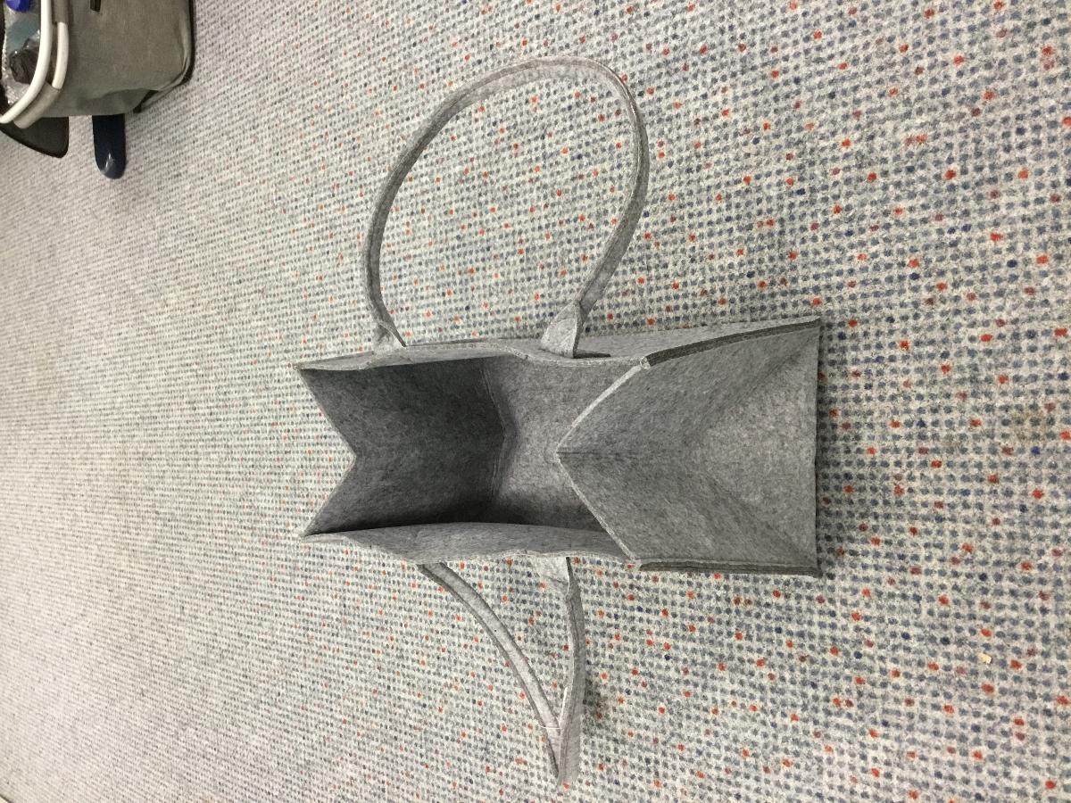 Einkaufstasche, Foto siehe Anlage,
- vollständig aus Spinnstoffen (laut Antrag aus Filz) gefertigt,
- mit zwei angenähten Tragegriffen,
- oben offen; ohne Verschluss,
- - ungefüttert; ohne Inneneinteilung,
- mit den Abmessungen: ca. 40 cm (Breite) x 24 cm (Höhe) x 21 cm (Tiefe),
- ohne Hinweise auf Handarbeit.

"Einkaufstasche, mit Außenseite aus Spinnstoffen, nicht handgearbeitet"