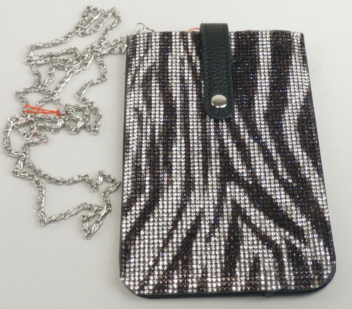 Etui für Mobiltelefon, sog. Catwalk Handytasche Glitzer, Foto siehe Anlage,
- mit zwei verschiedenen Außenseiten:
- - an einer Seite mit einer Außenseite aus Kunststofffolien (mit einem Sichtfenster aus klarsichtiger
    Kunststofffolie und einem Rand aus schwarzer, geprägter Kunststofffolie),
- - an der anderen Seite mit einer Außenseite aus flächendeckend aufgeklebten Strass-Steinchen
    aus Kunststoff (laut Antrag),
- mit einem abnehmbaren Trageriemen in Form einer Gliederkette aus unedlem Metall,
- mit einer Überschlaglasche mit einem Druckknopfverschluss,
- innen auf einer Seite gefüttert; ohne Einteilung,
- in den Abmessungen: 11 cm (Breite) x 17 cm (Höhe),
- die beiden die Außenseiten bildenden Stoffe (Kunststofffolie und Strass-Steinchen aus Kunststoff)
  sind nach dem Umfang etwa gleich, somit verleiht kein Stoff der gesamten Außenseite ihren wesent-
  lichen Charakter und das Etui ist der von den gleichermaßen in Betracht kommenden Unterpositionen
  (4202 9219 und 4202 9900) in der Nomenklatur zuletzt genannten Unterposition zuzuweisen.

"Ähnliches Behältnis (Etui für Mobiltelefon), anderes als in den Unterpositionen 4202 1110 bis 4202 3900
 genannte, mit Außenseite aus anderen Stoffen als in den Unterpositionen 4202 9110 bis 4202 9298
 genannte"
