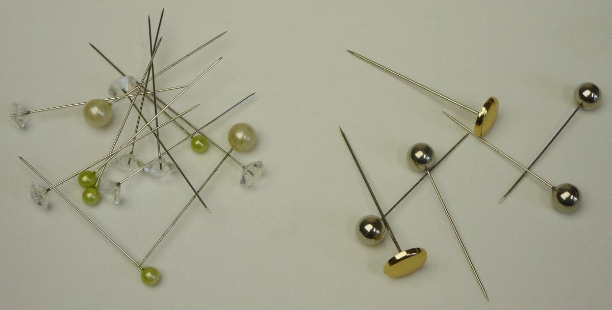 Es handelt sich um Stecknadeln aus Eisen (charakterbestimmend) mit einem Kopf aus Kunststoff. Je nach Ausfertigung weisen die Nadeln unterschiedliche Längen, unterschiedliche Kopfformen und -farben auf und sind zu unterschiedlichen Mengen in Kunststoff-Boxen verpackt.
- Antragstellerangaben -

Abbildung siehe Anlage.

Derartige Erzeugnisse gehören als "Stecknadeln aus Eisen" zum TARIC-Code 7319 4000 00.