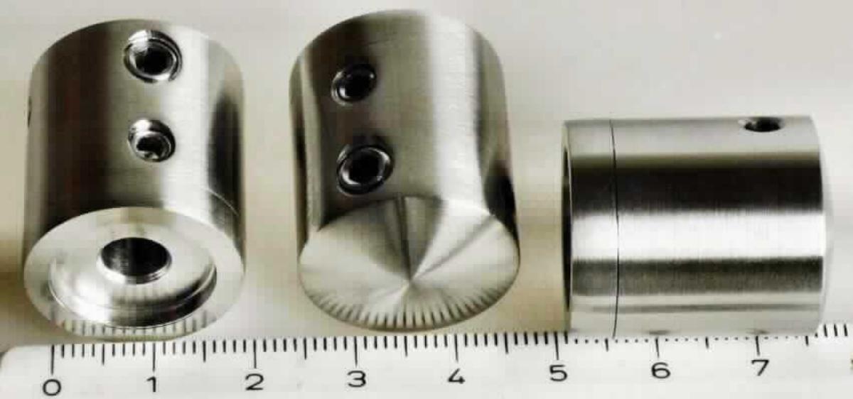 Es handelt sich um vollständig aus nicht rostendem Stahl gefertigte, zylindrische Erzeugnisse, die mit einer durchgehenden, kreisrunden Querlochung (Durchmesser: 3 mm) und zwei Madenschrauben versehen sowie mit einem, zu spezifischen Abstufungen, einer Rille, einem Kragen und einem Teller ausgearbeiteten Endstück ausgestattet sind. Das Endstück ist auf der Außenseite zu einer kreisrunden Vertiefung ausgearbeitet. Die Waren weisen eine matt gebürstete Oberfläche auf. Die speziell nach Zeichnung gefertigten und im Hinblick auf ihre Verwendung mit spezifischen Merkmalen ausgestatteten Erzeugnisse werden bei der Fertigung von Geländern als Querstabhalter für Seilführungen verwendet. Sie sind jeweils in Kunststoffolie und zu vier Stück in einem Pappkarton verpackt. 
Durchmesser: etwa 2 cm; Länge: etwa 2,5 cm.
- Antragstellerangaben -

Abbildung siehe Anlage. 

Derartige Erzeugnisse gehören als "andere Konstruktionsteile aus Stahl" zum TARIC-Code 7308 90 98 00.