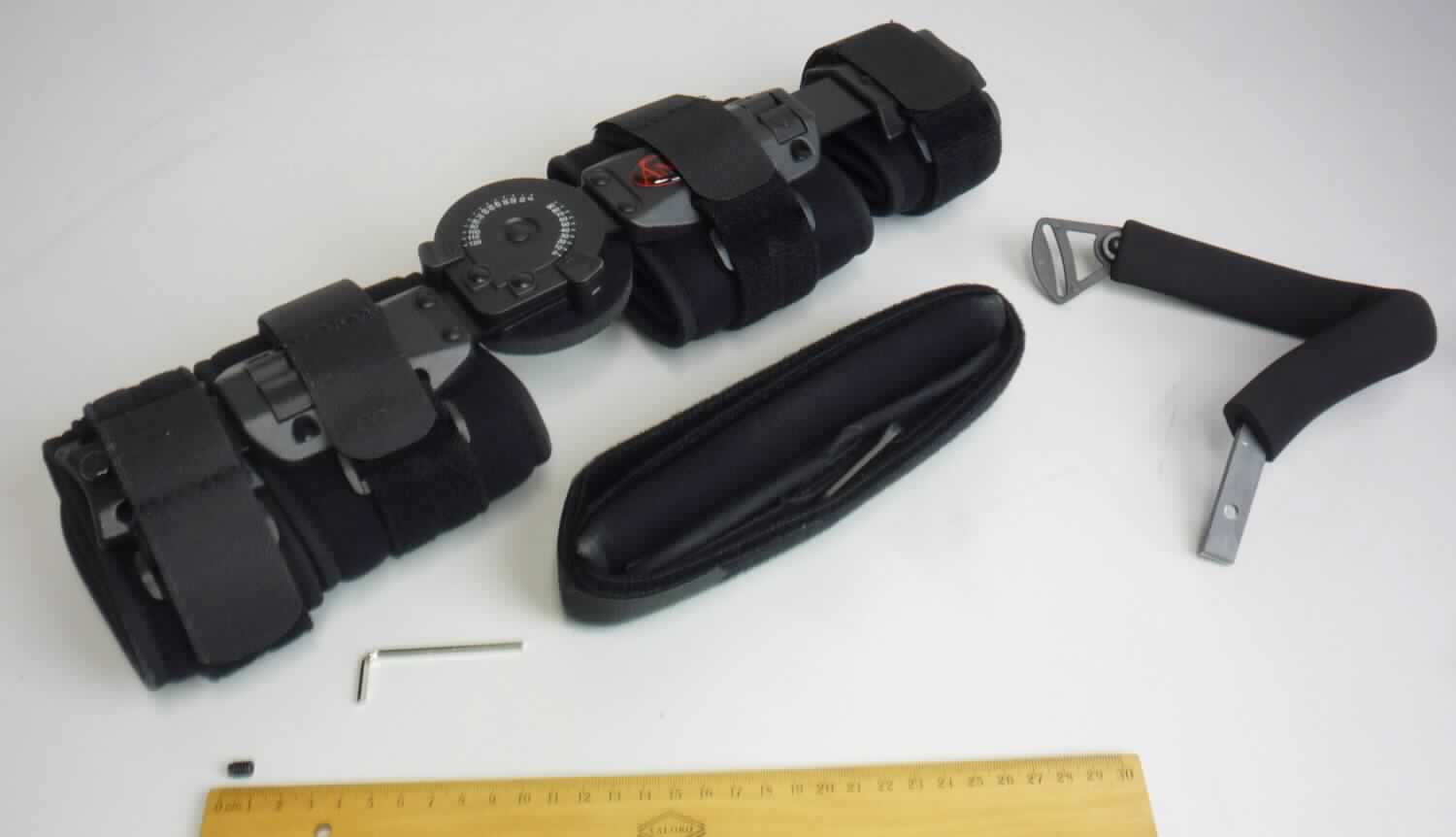 Ellenbogenorthese, sog. Telescoping ROM Elbow Brace, Art.-Nr. AT53009, in Form einer noch nicht zusammengesetzten Ware sowie einer Warenzusammenstellung in Aufmachung für den Einzelverkauf, im Wesentlichen bestehend aus 
1. einer insgesamt ca. 42 cm langen Vorrichtung aus zwei über ein einstellbares Gelenk miteinander verbundenen,
    in der Länge individuell einstellbaren Aluminiumschienen, an denen jeweils zwei Ober- und Unterarm-
    manschetten aus Spinnstoff mit Haken- und Flauschband zur Befestigung der Orthese am Arm des Patienten 
    befestigt sind (charakterbestimmender Bestandteil der Warenzusammenstellung in Bezug auf die Verwendung),
2. einem spezifischen, annähernd U-förmig geformten, gepolsterten Handgriff aus Metall, einseitig mit beweglicher 
    Kunststofflasche, auf der anderen Seite für ca. 50 mm ungepolstert und mit einer Bohrung mit Innengewinde 
    ausgestattet,
3. einem ca. 115 cm langen und 2,5 cm breiten Schultergurt aus Spinnstoff mit verschiebbarem Nackenpolster 
    und beweglicher Kunststofflasche versehen, an beiden Enden mit Klettverschlüssen,
4. einem Inbusschlüssel,
5. einer Inbusschraube, sog. Madenschraube zur Fixierung des Handgriffs und 
6. einer Gebrauchsanweisung. 
Am oberen und unteren Teil der Schiene ist jeweils ein mit einem Verriegelungsmechanismus ausgestattetes Kunststoffelement zur Längenverstellung der Schiene von 41 bis 52 cm angebracht. Über das Gelenk erfolgt eine stufenweise Einstellung des Bewegungsumfangs in 10° -Schritten (Flexion 0° bis 120°, Extension 0° bis 90°). Die Ober- und Unterarmmanschetten werden jeweils zusätzlich durch ein an der Außenseite verlaufendes und über Kunststoffösen befestigtes Klettverschlussband fixiert. 
Äußere Form: siehe Abbildungen in der Anlage. 
Die Vorrichtung dient hauptsächlich dem Stützen und Halten des Ellenbogengelenkes unter individuell einstellbarer Bewegungslimitierung bei frühfunktioneller postoperativer oder posttraumatischer Mobilisierung mit Beteiligung des proximalen Radius-Ulnargelenks und mit Bewegungsbegrenzung des Ellenbogengelenks. Beim optionalen Einsatz des Handgriffs kann die Vorrichtung zur Immobilisierung des proximalen Radius-Ulnargelenks verwendet werden. Zudem können Arm und Schulter durch Einsatz des Schultergurtes bei 90°-Lagerung entlastet werden.
Die Bestandteile der Warenzusammenstellung sind gemeinsam in einem Polybeutel verpackt und mit einer Anleitung in einem Pappkarton umverpackt.

Die Ware wird als "orthopädische Vorrichtung für Menschen" eingereiht.
