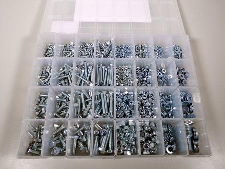 Es handelt sich um aus verzinktem Stahl (kein nicht rostender Stahl) gefertigte Schrauben mit Kopf mit Außensechskant und mit einem bis zum Kopf reichenden, metrischen Gewinde (M4, M5, M6, M8) mit stumpfem Gewindeende. Die Zugfestigkeit der Schrauben beträgt weniger als 800 MPa. Insgesamt 470 Schrauben in verschiedenen Abmessungen sind mit dazugehörenden Muttern mit Außensechskant, Sicherungsmuttern mit Außensechskant und Unterlegscheiben, jeweils aus Stahl, in einer mehrfach unterteilten, transparenten Kunststoffbox mit Etikett verpackt. 
Gesamtlänge: von etwa 10 bis etwa 40 mm. 
- Antragstellerangaben -

Abbildung siehe Anlage.

Derartige Erzeugnisse gehören als "andere Schrauben aus Stahl (kein nicht rostender Stahl), mit Gewinde, mit Kopf mit Außensechskant, mit einer Zugfestigkeit von weniger als 800 MPa, mit dazugehörenden Muttern und Unterlegscheiben" zur Codenummer 7318 1582 90 0 des Zolltarifs.

Nicht Unterposition 7318 11, da es sich bei Schrauben mit metrischem Gewinde nicht um Holzschrauben handelt.