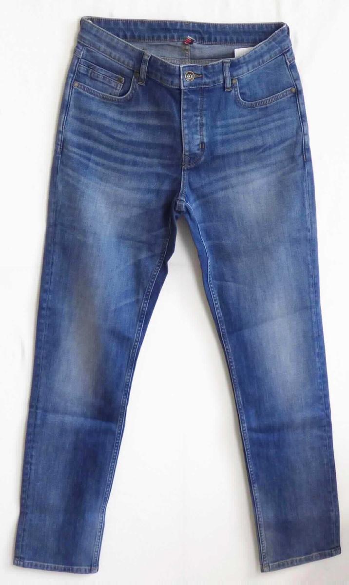 Lange Hose, sog. e.s. 5-Pocket-Stretch-Jeans, slim, A3-Art. 9586044, Größe 48, Foto siehe Anlage,
- in einem Polybeutel verpackt,
- aus ca. 0,8 mm dicken, buntgewebten, köperbindigen Denimgeweben aus laut Antrag 92 % Baumwolle,
  6 % Elastomultiester und 2 % Elasthan (beides synthetische Chemiefasern),
- in der Taille abschließend; mit einem ca. 4 cm breiten, angesetzten Bund mit Gürtelschlaufen,
- vorn mit einer Öffnung mit Knopfverschluss, verdeckt von einer Patte von links über rechts (Männerkleidung),
  die im Taillenbund mit einem Knopf geschlossen wird,
- vorn mit zwei eingesetzten, offenen Taschen und einer aufgesetzten, kleinen Tasche sowie mit zwei 
  aufgesetzten, offenen Gesäßtaschen,
- mit knöchellangen Hosenbeinen; an den Beinabschlüssen durch Umschlagen und Festnähen gesäumt,
- keine Arbeits- und Berufskleidung.

"Lange Hose, aus Geweben, für Männer, aus Baumwolle, keine Arbeits- und Berufskleidung, aus Denim"