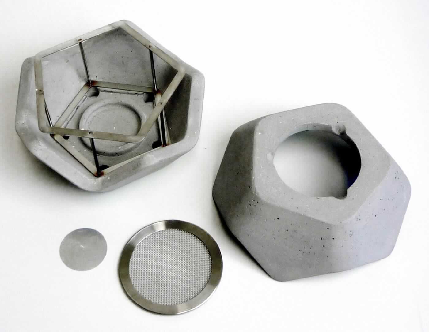 Angaben:
Duft und Räucherofen "FLOW":
- kombiniert verschiedene Varianten der Raumbeduftung: Schale für Duftmischungen, Wachs, Granulat, uvm. 
- Sieb und Metallplättchen für Räuchermischungen 
- ideal zum sanften Räuchern von Harzen und Kräutern über dem Teelicht -> verglimmt langsam und verströmt deren feinen Duft 
Inhalt: 
- Duft- und Räucherofen "FLOW" 
- Glasschale, Sieb, Aluplättchen 
- Räuchermischung 
Material: Beton.

Warenbeschaffenheit:
Graues, zweiteiliges Windlicht in Form eines Vieleckes, mit Möbelschonern auf der Unterseite. 

Befund:
Waren aus Zement, Beton oder Kunststein, auch bewehrt.

Zusammengesetzte Ware, bei der im Sinne der AV 3b)  der Duft- und Räucherofen aus Beton im Hinblick auf die Verwendung als charakterbestimmend angesehen wird.