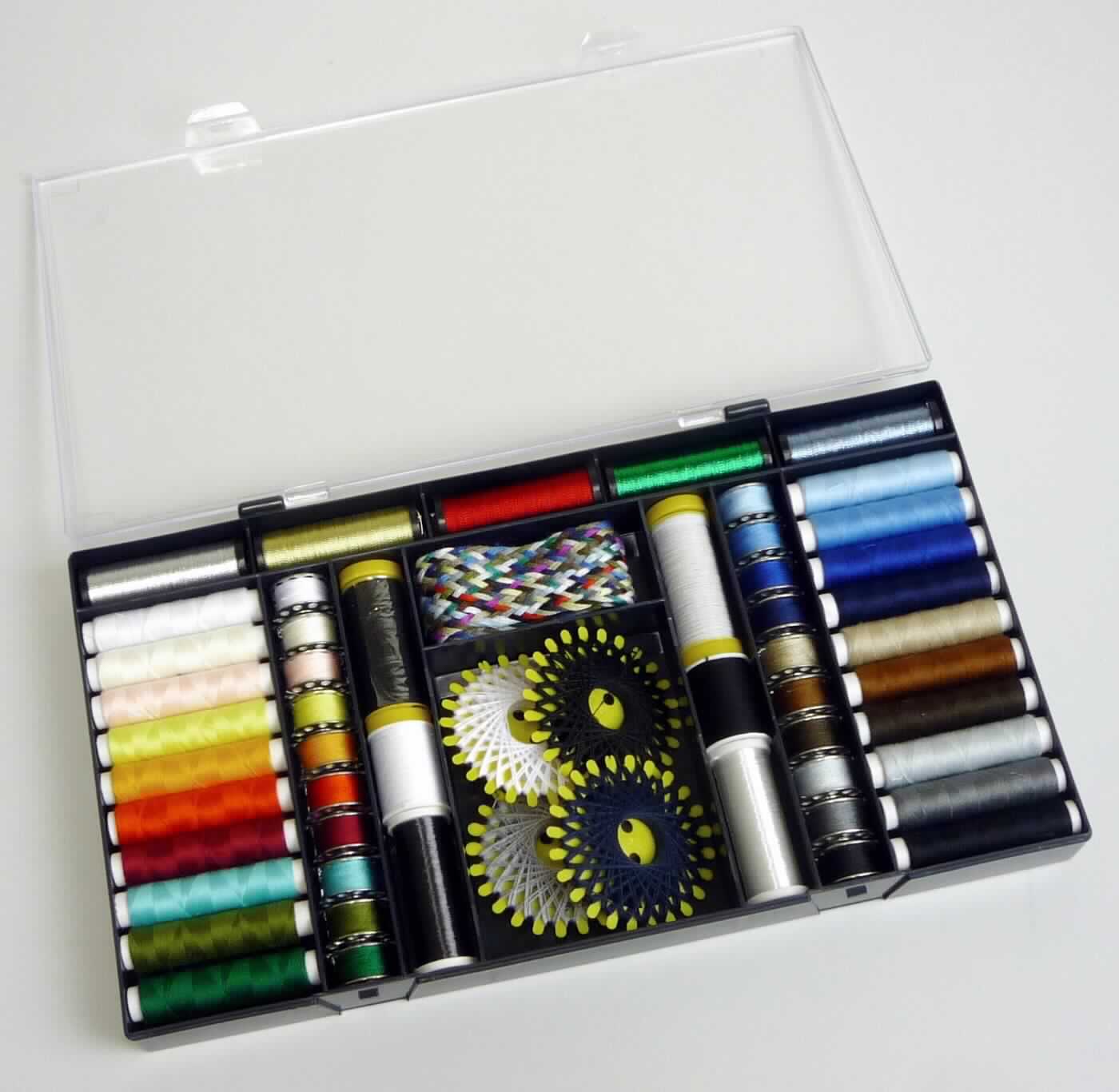 Nähsortiment, sog. Nähgarn Box, Foto siehe Anlage,
- Warenzusammenstellung, bestehend aus sechsundvierzig verschiedenen Nähgarnen, zwei sog. Transparent-
  Nähgarnen, zwei sog. Gummi-Nähfäden, fünf sog. Glanzgarnen und einem sog. Garnzopf,
- gemeinsam in einer speziell dafür hergerichteten Kunststoffbox für den Einzelverkauf aufgemacht und zur 
  Befriedigung eines speziellen Bedarfs zusammengestellt,
- laut Untersuchungsergebnis:
-- Nähgarne:
--- zwanzig sog. Syngarn-Allesnähfäden (Lauflänge: laut Antrag 50 m), zwanzig sog. Unterfadenspulen 
    (Lauflänge: laut Antrag 25 m) und vier sog. Spezial-Sternzwirne (Lauflänge: laut Antrag 20 m): 
    aus synthetischen Spinnfasern (Polyester),
--- zwei sog. Obergarne (Lauflänge: laut Antrag 50 m): aus Baumwolle,
--- auf einer Unterlage (Spulen aus Metall oder Kunststoff, Sternkarten aus Kunststoff bzw. Papphülsen) 
    aufgemacht
--- mit einem Gewicht einschließlich der Unterlage von unter 125 g (