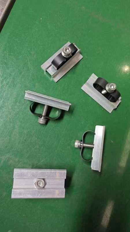 Bei der sog. Solarmodulmittelklemme und auch der sog. Solarmodulendklemme handelt es sich um mehrteilige und schon zusammengesetzte Befestigungselemente bestehend aus
- einem hutartig geformten Profilabschnitt (Abmessungen: Länge ca. 70 mm, Breite ca. 38 mm und 
  Höhe ca. 13 mm) mit einer mittigen Lochung (Solarmodulmittelklemme) oder
- einem Z-förmigen Profilabschnitt mit Verlängerung des einen äußeren Schenkels über die Mitte 
  des mittleren Schenkels hinaus (Abmessungen: Länge ca. 70 mm, Breite ca. 28 mm und 
  Höhe ca. 32,3 mm) mit einer mittigen Lochung (Solarmodulendklemme)
jeweils aus einer Aluminiumlegierung mit gewichtsmäßig vorherrschendem Aluminiumgehalt.
Durch die jeweilige Lochung ist eine Innensechskantschraube mit Unterlegscheibe geführt und mit einer Sechskantmutter versehen. Schraube, Unterlegscheibe und Mutter sind aus Stahl. Zusätzlich ist das Erzeugnis mit einem Abstandhalter aus Kunststoff versehen.
Die Erzeugnisse stellen sich als Konstruktionsteile dar und dienen als Mittelklemmen oder Endklemmen der Montage (Aufnahme und Positionierung) von Solarmodulen auf weiteren Konstruktionselementen einer Unterkonstruktion zur Tragung von Solarmodulen (z. B. auf Dächern).
- Angaben laut Antragsteller -

Im Hinblick auf die Bedeutung für die Verwendung bestimmt das unedle Metall gegenüber dem Kunststoff den Charakter der Erzeugnisse.
Aluminium überwiegt gewichtsmäßig gegenüber dem Stahl.

Abbildungen siehe Anlagen

Derartige Erzeugnisse gehören als "andere (als in den TARIC-Codes 7610 9090 10 bis 7610 9090 92 genannte) Konstruktionsteile aus Aluminium" zum TARIC-Code 7610 9090 95.