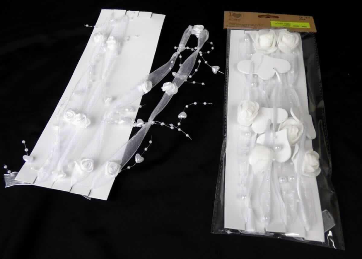 Posamentierware, sog. Perlengirlande mit Rosen, Art. Nr. 205043, Foto siehe Anlage,
- auf einer rechteckigen Unterlage aus Pappe aufgewickelt und in einem Polybeutel verpackt,
- als Meterware, laut Antrag mit einer Länge von 120 cm,
- bestehend aus:
-- einem ca. 15 mm breiten, einfarbigen Gewebeband aus Spinnstoffen der Position 5806, das beidseitig in 
   regelmäßigen Abständen mit jeweils neun aus einem spiralförmig zusammengeklebten Zuschnitt aus einfarbigen
   Geweben gefertigten stilisierten Blüten verziert ist (keine in Blumenbindetechnik gefertigte, künstliche Blumen der 
   Position 6702),
-- einem synthetischen Monofil (Durchmesser: weniger als 1 mm),
-- zehn ca. 15 cm langen Kunststoffsträngen (Durchmesser: weniger als 1 mm), auf die in regelmäßigen Abständen 
   Perlen (Durchmesser: ca. 3 mm) und Herzen (Durchmesser: ca. 1 cm) aus Kunststoff aufgefädelt und fixiert
   sind (Waren der Position 3926), 
- das Gewebeband und das Monofil sind in regelmäßigen Abständen miteinander verknotet und die Kunststoff-
  stränge zusätzlich an den Knotenpunkten aufgeknotet,
- an den Enden geschnitten,
- kein Festartikel der Position 9505, da ohne eindeutigen Bezug zu einem Fest,
- im Hinblick auf den Umfang und das äußere Erscheinungsbild bestimmen die Gewebe aus Spinnstoffen
  gegenüber dem Kunststoff den Charakter der Ware.

"Posamentierware, als Meterware, ohne Stickerei, nicht aus Gewirken oder Gestricken"