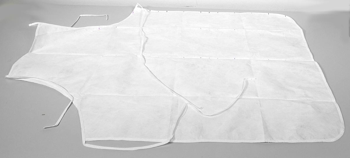 Schürze, in Erwachsenengröße, Foto siehe Anlage,
- in einem Polybeutel verpackt,
- als Latzschürze gearbeitet; in den max. Abmessungen (L x B) von ca. 106 cm x 70 cm,
- aus ca. 0﻿,﻿1 mm dicken Vliesstoffen der Position 5603 aus laut Antrag Polyethylen (synthetische 
  Chemiefasern),
- an allen Rändern mit schmalen Streifen aus den oben genannten Vliesstoffen eingefasst, die zu
  einem Nackenträger und etwa in Taillenhöhe zu Bindebändern gearbeitet sind,
- wird als Schürze nicht vom Warenkreis der Unterposition (KN) 6210 1092 erfasst.

"Kleidung aus Erzeugnissen der Position 5603, kein Einwegkittel, von der durch Patienten bzw.
 Chirurgen bei chirurgischen Eingriffen verwendeten Art"