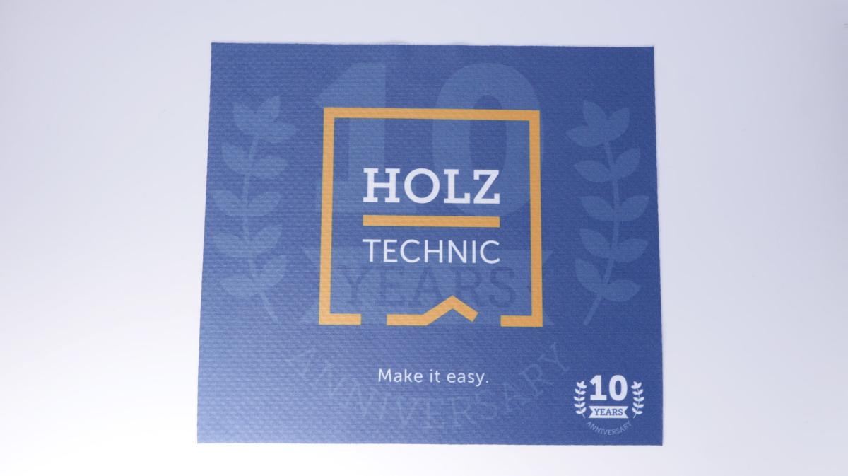 Kuliergewirke, Foto siehe Anlage,
- 2 Stück in einem Polybeutel verpackt,
- lediglich rechteckig heiß zugeschnitten (somit nicht konfektioniert, damit keine Ware der Position 6307),
- in den Abmessungen von ca. 23 cm x 20 cm,
- aus laut Antrag synthetischen Chemiefasern (80 GHT Polyester und 20 GHT Polyamid),
- auf der Vorderseite mit großflächigen Aufdrucken versehen,
- auf der Rückseite mit Noppen aus Kunststoff bedruckt,
- keine Elastomergarne oder Kautschukfäden enthaltend,
- ohne Flor- oder Schlingenoberfläche,
- keine Raschelspitze.

"Gewirke, mit einer Breite von weniger als 30 cm, anderes als solche der Positionen 6001 und 6002,
 aus synthetischen Chemiefasern, keine Raschelspitze"