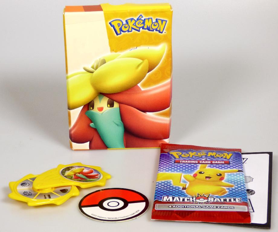 Durch Warenmuster sowie Anleitung veranschaulichtes Kartenspiel "Mc Donald's Pokemon - MEL + GY + AT - 2022, Motiv Gossifleur Yellow" für zwei bis vier Personen, bestehend aus vier buntbedruckten Spielkarten aus Pappe sowie Zubehör in Form eines in der Hand zu haltenden Drehrades aus gelbem Kunststoff mit sechs aufgeklebten Kategoriefeldern und einem kreisrunden, bunt bedruckten Chip aus Pappe. Die Bestandteile sind mit einer Spielanleitung in einer bunt bedruckten Pappschachtel aufgemacht. 
Die vier Karten sind mit Pokemoncharakteren und ihren Eigenschaften (sechs Kategorien) bedruckt und werden an die Spieler verteilt. Eine Person dreht das Kategorienrad und wirft den Chip. Die erscheinende Kategorie ist von den Spielern auf ihrer Spielkarte zu suchen und der Wert zu nennen. Der geworfene Chip bestimmt für eine Spielrunde, ob der höhere oder niedrigere Wert gewinnt. Nach jeder Runde dreht eine andere Person das Kategorienrad und wirft den Chip.
Eine Wechselwirkung bzw. Interaktion zwischen den Spielern durch die Karten findet durch das Vergleichen der abgelesene Kategoriewerte (z.B. Kraftpunkte, Gewicht, Größe der Kartencharaktere) statt.

Die Ware ist zolltarifrechtlich als "Gesellschaftsspiel, anderes als von den Codenummern 9504 2000 00 0 bis 9504 3020 00 0 erfasst, Spielkarten" einzureihen.