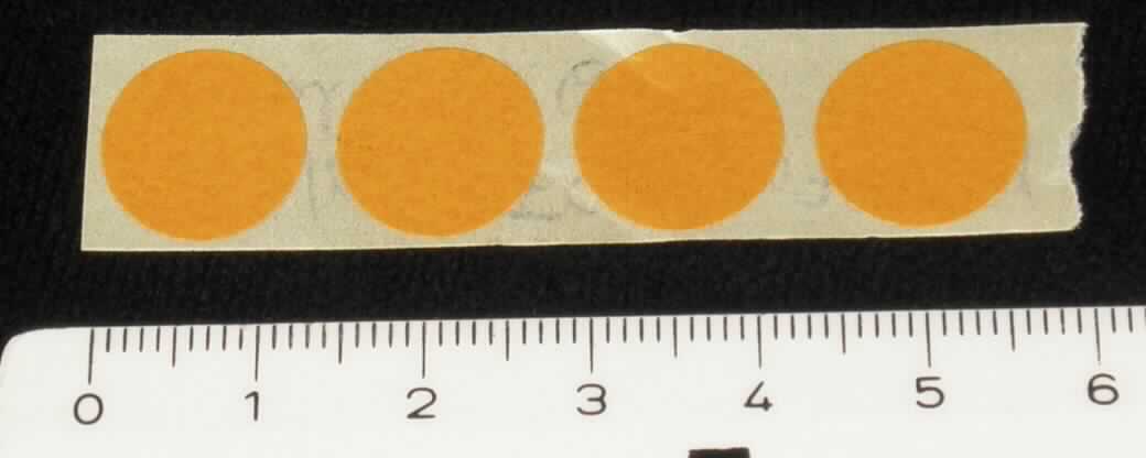 Angaben des Antragstellers:
Etiketten mit GAMMA-Indikator, Durchmesser: 12,5 mm
Aufbau: Strahlen-Indikator gelb, Papier selbstklebend, Lackfirnis
Aufmachung: 5000 Punkte auf der Rolle
Bei den Etiketten handelt es sich um Prozessindikatoren für Sterilisationsanwendungen mit Gamma- oder Betastrahlen und für eine Strahlendosis von 25 bis 50 kGy. Die rote Endfarbe wird bei einer Dosis von ca. 20 kGy erreicht.

Untersuchungsergebnisse an Warenmustern:
Orangefarbene, runde, einseitig selbstklebende Etiketten (Durchmesser: ca. 13 mm). Diverse Etiketten befinden sich auf einem beschichteten Papierträgerstreifen.

Befund:
Diagnostik- oder Laborreagenz auf einem Träger und zubereitete Diagnostik- oder Laborreagenzien, auch auf einem Träger, ausgenommen Waren der Position 3002 oder 3006