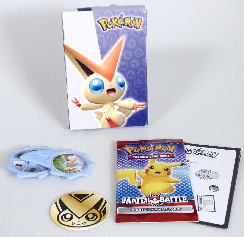 Durch Warenmuster sowie Anleitung veranschaulichtes Gesellschaftsspiel "Mc Donald's Pokemon - MEL + GY + AT - 2022, Motiv Victini Dark Blue" für zwei bis vier Personen, bestehend aus vier buntbedruckten Spielkarten aus Pappe sowie Zubehör in Form eines in der Hand zu haltenden Drehrades aus fliederfarbenem Kunststoff mit sechs aufgeklebten Kategoriefeldern und einem kreisrunden, bunt bedruckten Chip aus Pappe. Die Bestandteile sind mit einer Spielanleitung in einer bunt bedruckten Pappschachtel aufgemacht. 
Die vier Karten sind mit Pokemoncharakteren und ihren Eigenschaften (sechs Kategorien) bedruckt und werden an die Spieler verteilt. Eine Person dreht das Kategorienrad und wirft den Chip. Die erscheinende Kategorie ist von den Spielern auf ihrer Spielkarte zu suchen und der Wert zu nennen. Der geworfene Chip bestimmt für eine Spielrunde, ob der höhere oder niedrigere Wert gewinnt. Nach jeder Runde dreht eine andere Person das Kategorienrad und wirft den Chip.
Eine Wechselwirkung bzw. Interaktion zwischen den Spielern durch die Karten findet durch das Vergleichen der abgelesenen Kategoriewerte (z.B. Kraftpunkte, Gewicht, Größe der Kartencharaktere) statt.

Die Ware ist zolltarifrechtlich als "Gesellschaftsspiel, anderes als von den Codenummern 9504 2000 00 0 bis 9504 3020 00 0 erfasst, Spielkarten" einzureihen.