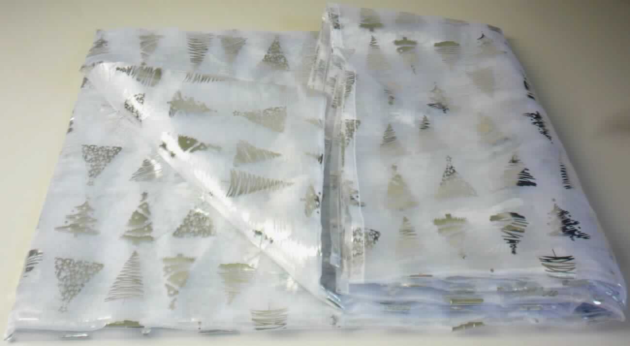 Tischwäsche, sog. Organza Deko Decke, NAN 7106553, Foto siehe Anlage,
- rechteckig, laut Antrag in den Abmessungen 140 cm x 300 cm,
- aus einem ca. 0,2 mm dicken, durchscheinenden, bedruckten Gewebe aus laut Antrag 100 % Polyester 
  (synthetische Chemiefasern),
- an den Rändern durch Umschlagen und Festnähen gesäumt (somit konfektioniert),
- wird üblicherweise gewaschen; kennzeichnet sich nach Material und Verwendungszweck als Tischwäsche.

"Tischwäsche aus Spinnstoffen, aus Geweben, aus Chemiefasern"