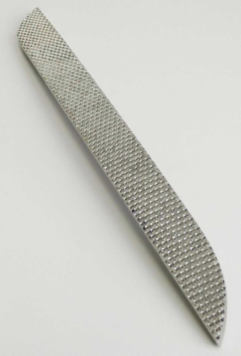 Es handelt sich um einen Einsatz aus Nickel, zum Spritzgießen von Rückstrahlern aus Kunststoff.
Das spezifisch geformte, etwa 23 x 2 x 1 cm (L x B x D) große Erzeugnis weist auf der Unterseite acht runde, teilweise mit Innengewinde versehene Ausparungen zum Einsetzen in die Form auf und stellt somit ein notwendiges und erkennbares Teil der Herstellungsform für Rückstrahler dar.

Das Erzeugnis ist als "Teil einer Form für Kunststoffe, zum Spritzgießen oder Formpressen" einzureihen.
