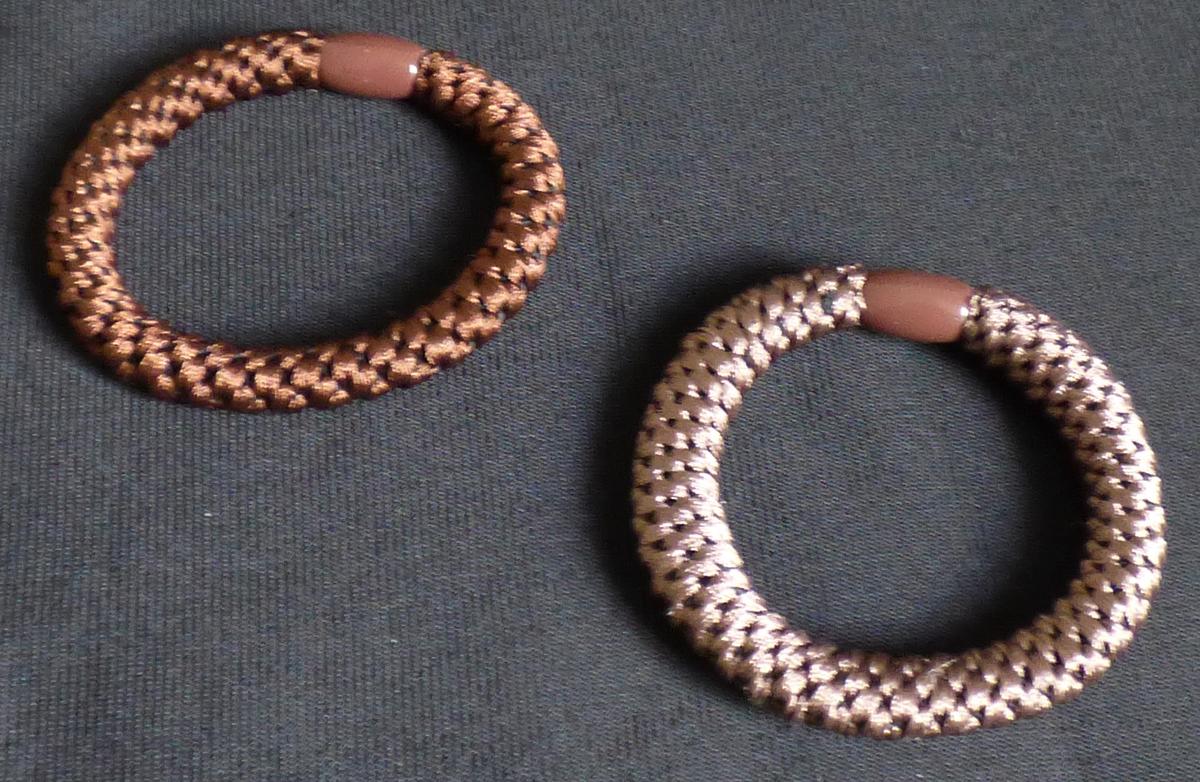 Haargummis, Foto siehe Anlage,
- laut Antrag als Zehnerpack; veranschaulicht durch zwei Warenmuster in unterschiedlichen 
  Farbausführungen,
- jeweils aus einem elastischen Rundgeflecht ohne festes Gefüge mit einer Seele aus Spinnstoffen 
  (Meterware der Position 5808),
- an den Enden durch eine ca. 1,1 cm lange Hülse aus laut Antrag Kunststoff zu einem Ring zu-
  sammengefügt (somit konfektioniert), 
- ohne Hinweise auf Handarbeit,
- wird zum Zusammenhalten des Haares getragen,
- in Anbetracht des textilen Charakters wird die Ware nicht vom Warenkreis der Position 9615 
  erfasst,
- individuelles (selbstständiges) Einzelstück, das eine Ergänzung von Kleidung darstellt.

"Anderes konfektioniertes Bekleidungszubehör (Haargummis) aus Spinnstoffen, nicht aus 
 Gewirken oder Gestricken, nicht handgearbeitet"
