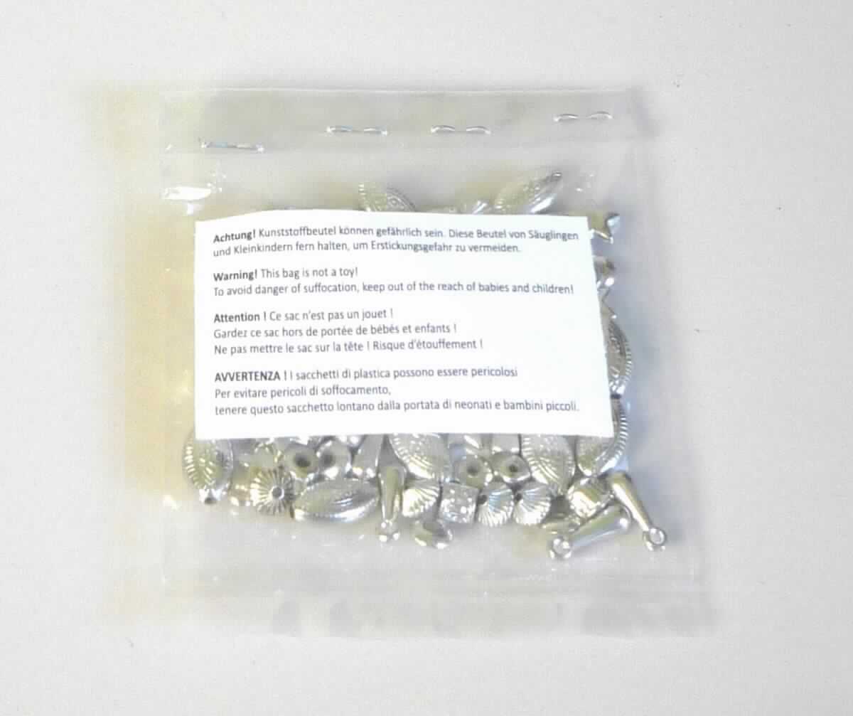 Es handelt sich um sog. Zwischenelemente aus unedlen Metallen (Stahl oder Kupfer, lt. Antragstellerangabe), in verschiedenen Formen (tropfen-, stern-, würfel-, zylinder- oder elypsenförmig) zum Herstellen von Schmuck. Die Zwischenelemente sind entweder mit einer durchgängigen Lochung versehen oder zu einer Öse ausgearbeitet. Sie weisen auf der Außenseite je nach Form musterbildende Einkerbungen auf.

Größen: zwischen 4 mm und 14 mm.

Die Waren sind zu 70 Stück in einem Kunststoffbeutel verpackt.

Abbildung siehe Anlage.

Derartige Erzeugnisse gehören als "Perlen aus unedlen Metallen" zur Codenummer 8308 9000 90 0 des Zolltarifs.