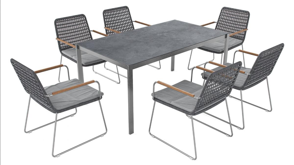 Bei dem sog. "Set MELISSA L - 5508L" handelt es sich um eine Warenzusammenstellung bestehend aus
- sechs stappelbaren Stühlen 65 x 58 x 85 cm (LxBxH) und
- einem Tisch 160 x 90 x 75 cm

Die Sitzflächen und Rückenlehnen der Stühle sind aus Flechtwerk und sind mit passgenauen, losen aufgelegten Sitzkissen ausgestattet. Der Tisch hat eine eingelegte Stein-Effekt Glasplatte. Er ist dazu ausgelegt, während des Sitzens auf den dazugehörigen Sitzmöbeln an ihm zu essen. Der Esstisch ist daher charakterbestimmend für die Warenzusammenstellung.

Bei dem aus zwei unterschiedlichen Stoffen bestehenden Möbel wird der stoffliche Charakter des Tisches weder vom Metallgestell (Bedeutung für die Verwendung als Stabilität verleihendes Element) noch von der Glasplatte (Stoff mit dem höchsten Wert) bestimmt. Das Erzeugnis ist in die zuletzt genannte, der gleichermaßen in Betracht kommenden Unterpositionen einzureihen. Hinweise für Handarbeit liegen nicht vor. Die Ware dient der Einrichtung von Wohnungen und ist dazu bestimmt, auf den Boden gestellt zu werden.

Die in drei Kartons verpackte Warenzusammenstellung wird als "anderes als von den Positionen 9401 bis 9402, sowie den Unterpositionen (HS) 9403 10 bis 9403 83 erfasstes Möbel, aus Glas, nicht handgearbeitet " eingereiht.