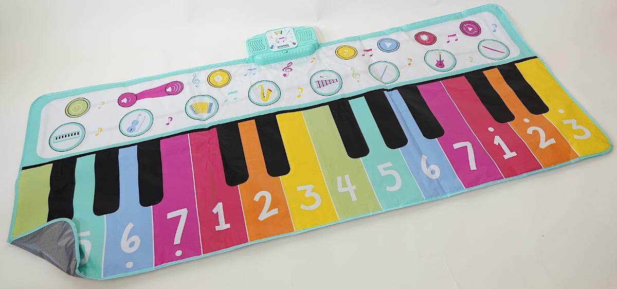 Bei der durch ein Warenmuster veranschaulichten und als "Piano Matte für Kinder" bezeichneten Ware handelt es sich um ein Musikspielzeuggerät
- die Nachbildung der Klaviatur eines Musikinstrumentes (Klavier bzw. Keyboard) in
  Form einer Tastatur-Bodenmatte darstellend,
- mit den Abmessungen von etwa 180 cm x 80 cm,
- aus Kunststoffen hergestellt, 
- mit 24 bespielbaren, zum Teil mit Zahlen bedruckten "Tasten" sowie Feldern mit
  Instrumentenabbildungen und anderen Symbolen (z. B. "Play", einer Note, zur
  Regulierung der Lautstärke),
- am oberen Ende zusätzlich mit einem Kunststoffgehäuse mit zwei Lautsprechern,
  einem Ein-/Ausschalter und einem Batteriefach (Batterien nicht enthalten) 
  ausgestattet,
- ist mit den Füßen zu bespielen und dient der spielerischen Unterhaltung von
  Kindern, 
- aufgrund der Art der Ware, der Größe und einer fehlenden Interaktion zwischen
  Gerät und Kind kommt eine Einreihung in die Unterposition (KN) 9503 0087 nicht
  in Betracht. 

Derartige Erzeugnisse werden zolltariflich als "Musikspielzeuggerät, nicht aus Holz handgearbeitet" eingereiht.