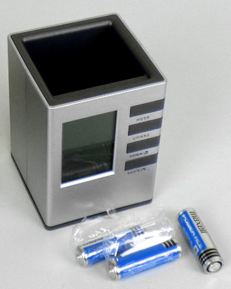 Bei der LCD-Tischuhr einschließlich Stifteköcher "Desk Set 2000", Artikel-Nr. 54010, handelt es sich um eine zusammengesetzte Ware, ca. 8 cm x 11 cm x 8 cm groß (Breite x Höhe x Tiefe), bestehend aus:
- einem oben offenen Kunststoffbehältnis zur Nutzung als Stiftehalter;
- einem elektrisch betriebenen Wecker (2 Batterien) mit digitaler Anzeige der Uhrzeit (Stunde und Minuten), des Datums und des Wochentages (Größe der Platine: 6,8 cm x 5,8 cm x 0,8 cm = Länge x Breite x Dicke; somit kein Kleinuhr-Werk i.S.d. Anmerkung 3 zu Kapitel 91), gemeinsam mit einem integrierten Thermometer (Anzeige der Innentemperatur in Grad Celsius und Grad Fahrenheit möglich).
Neben der vorderseitigen Anzeigefläche befinden sich vier Funktionstasten; das Batteriefach befindet sich auf der Unterseite des Korpusses.

Ein charakterbestimmender Bestandteil hinsichtlich des Stiftehalters, der Uhr und des Thermometers ist nicht feststellbar. Die zusammengesetzte Ware ist deshalb von den gleichermaßen in Betracht kommenden Positionen der zuletzt genannten Position zuzuweisen.
 
Das Erzeugnis ist in einem Pappkarton verpackt.

Die zusammengesetzte Ware ist als "andere als in den Positionen 9101 bis 9104 erfasste Uhr, Wecker, elektrisch betrieben" einzureihen.