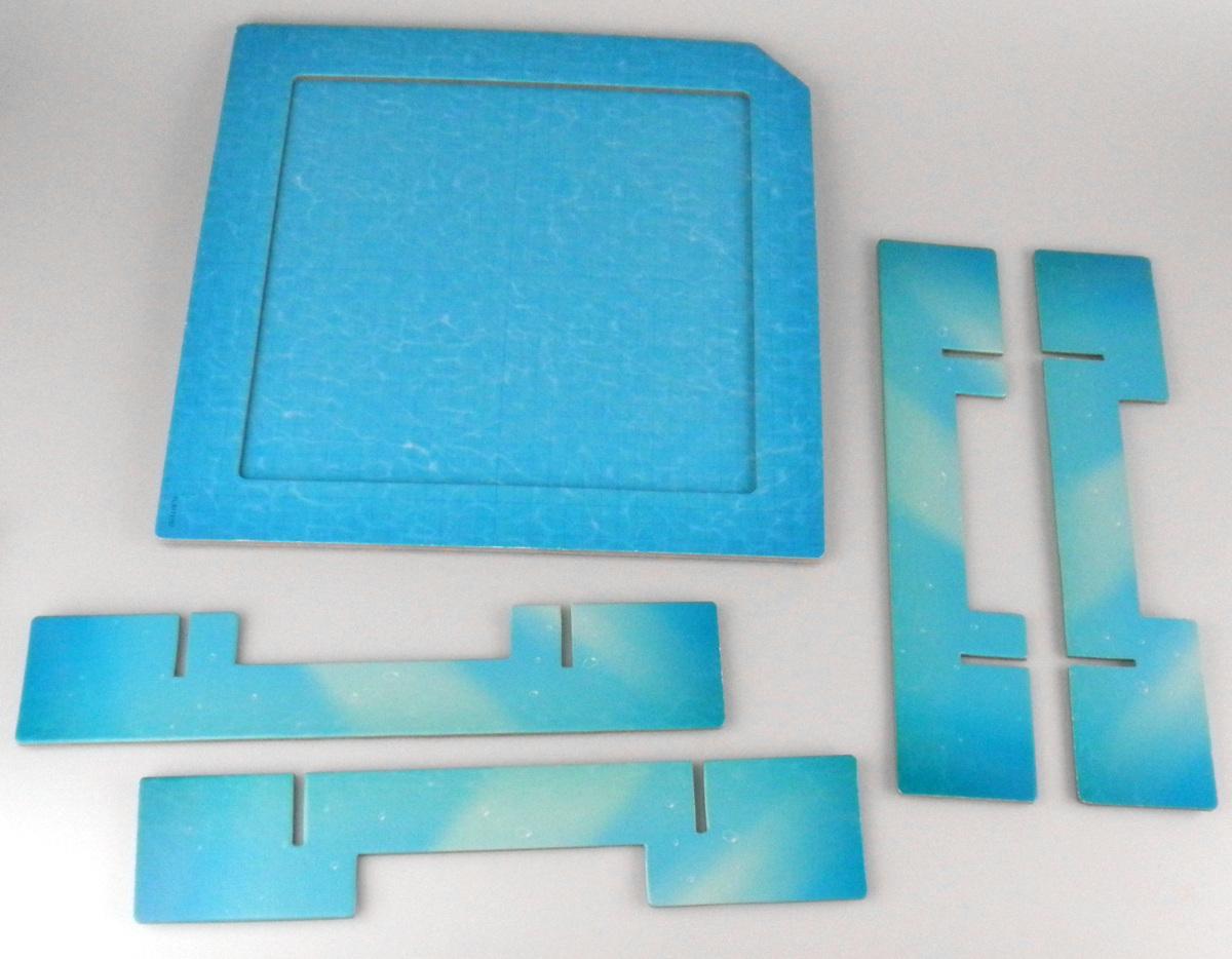 Bei den durch Antragsangaben und ein Warenmuster veranschaulichten und als "Schwimmbecken" bezeichneten Erzeugnissen handelt es sich um fünf spezifische Bestandteile des Schiebe-Puzzles "Logic! Games Milos Wasserpark", in Form von einem sog. Spielplan und vier Steckkreuzteilen aus Pappe.

Der annähernd quadratische, in Blautönen bedruckte Spielplan (Abmessungen ca. 255 x 255 x 6 mm) bildet die eingegrenzte Grundfläche des Schiebe-Puzzles. Er ist dazu bestimmt, u.a. 13 mit stilisierten Motiven versehene Papp-Puzzle-Plättchen (nicht Gegenstand dieser vZTA) so aufznehmen, dass sie durch den Spieler verschoben werden können.
Die vier mit speziellen Aussparungen versehenen Steckkreuzteile (Abmessungen jeweils ca. 250 x 50 x 3 mm) bilden den Unterbau des sog. Spielplans. Mit den Steckkreuzteilen wird dieser passgenau in den Schachtelboden des Schiebe-Puzzles eingelassen (Logik-, Denk- und Geduldspiel zur spielerischen Unterhaltung eines einzigen Spielers; Position 9503).

Spielplan und Steckkreuzteile sind gemeinsam in eine Papierbanderole eingefasst.

Derartige Erzeugnisse werden zolltarifrechtlich als "Teile, erkennbar hauptsächlich bestimmt für "Puzzle, nicht aus Holz" eingereiht.
