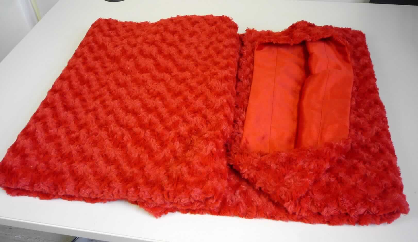 Decke, sog. Kuscheldecke "Florenza", Foto siehe Anlage,
- mit einer umgebundenen Schleife mit aufgezogener, bedruckter Pappkarte in einem Polybeutel verpackt,
- rechteckig, in den Abmessungen von laut Antrag: 150 cm x 200 cm,
- zweilagig gearbeitet, mit einer Lage (Schauseite) aus langflorigen Plüschgewirken und einer Lage aus 
  einseitig (Außenseite) gerauten, einfarbigen Samtgewirken; beide Gewirke aus laut Antrag 100 % Polyester 
  (synthetische Chemiefasern),
- an den Rändern zusammengenäht (somit konfektioniert),
- ohne elektrische Heizvorrichtung.

"Decke, aus Spinnstoffen, ohne elektrische Heizvorrichtung, aus synthetischen Chemiefasern, aus Gewirken"
