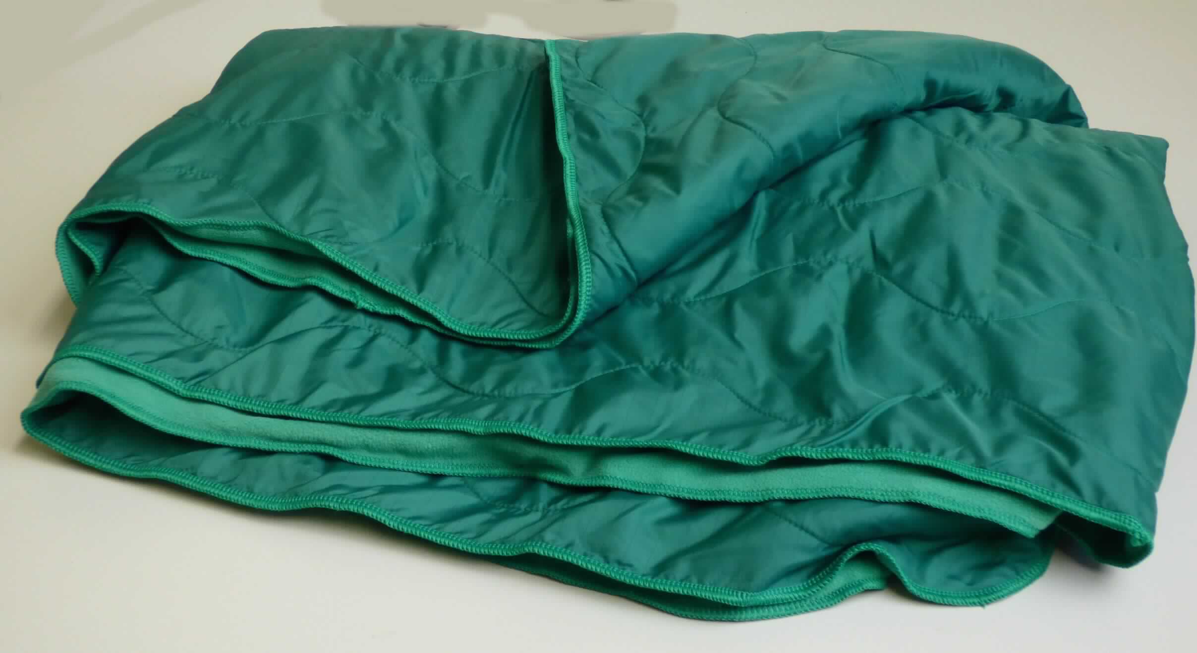Decke, sog. Fleece-Wärmedecke, Foto siehe Anlage,
- annähernd rechteckig, mit abgerundeten Ecken; in den Abmessungen: ca. 220 cm x 122 cm,
- zweilagig gearbeitet (versteppt), mit einer Lage aus 2,2 mm dicken, einfarbigen, beidseitig gerauten Gewirken
  (sog. Fleece) aus laut Antrag 100 % Polyester (synthetische Chemiefasern) und einer Lage aus 0,1 mm dicken,
  einfarbigen Geweben aus laut Antrag 99 % Polyester und 1 % Carbon,
- ohne elektrische Heizvorrichtung,
- an den Rändern durch Überwendlichnähte gesäumt (konfektioniert),
- ohne Polsterung oder Füllung; somit keine Ware der Position 9404,
- insbesondere im Hinblick auf die Dicke verleihen die Gewirke der Ware den wesentlichen Charakter.

"Decke, aus Spinnstoffen, ohne elektrische Heizvorrichtung, aus synthetischen Chemiefasern, aus Gewirken"