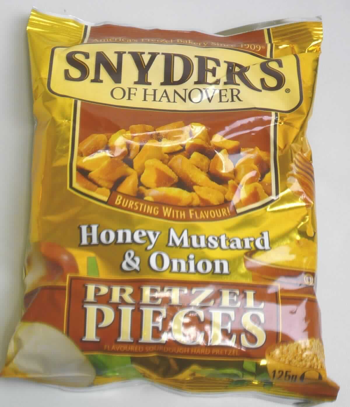 Knabbergebäck mit Honigsenf- und Zwiebelgeschmack

Antragsangaben: Bretzelstücke, Geschmacksrichtung "Honey Mustard and Onion"

Beschreibung des vorgelegten Warenmusters: 
Knuspriges, aus mundgerechten Bruchstücken (bis zu 4,8 cm x 2 cm) von handelsüblichen Laugenbretzeln 
bestehendes Knabbergebäck, unregelmäßig mit einer gelblichen, fettigen Würzschicht überzogen. 
Geschmack: salzig - süßlich - würzig, nach krossem Knabbergebäck mit Senf, Honig und Zwiebeln
Verpackung: Mehrsprachig bedruckter braun-goldfarbener Originalschlauchfolienbeutel mit Abbildung des Inhaltes, der Aufdruck enthält Angaben zum Erzeugnis (Sauerteig-Brezelstückchen mit Honig-Senf- und Zwiebelgeschmack), zur Füllmenge (125 g), zu den Zutaten (siehe Feld 8) und Nährwertangaben.

Stärke/Glucose*: 50 bis weniger als 75 GHT
Saccharose/Invertzucker/Isoglucose**: 0 bis weniger als 5 GHT
Milchfett***: 0 bis weniger als 1,5 GHT
Milchprotein***: 0 bis weniger als 2,5 GHT

*: festgestellt gemäß VO (EG) Nr. 900/2008, VO (EU) Nr. 118/2010
**: festgestellt gemäß VO (EG) Nr. 900/2008
***: abgeleitet aus der Zutatenliste

Andere nicht gesüßte Backware, Knabbergebäck aus Bretzeln