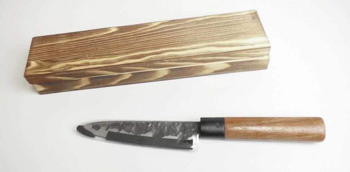 Küchenmesser

- mit schneidender, feststehender Klinge aus Stahl, mit geraden Klingenschliff und einem
  Griff aus Holz

- mit einer Klingenlänge von ca. 14,5 cm und einer Gesamtlänge von ca. 28 cm

- zur Verwendung in der Küche beim Zubereiten von Speisen

- in eine speziell zur Aufnahme des Messers gestalteten und zum dauernden Gebrauch
  geeigneten Holzkiste mit abnehmbaren Deckel eingelegt und mit einer bedruckten
  Pappbanderole verpackt

Abbildung siehe Anlage.

Derartige Erzeugnisse gehören als "andere Messer als Tischmesser mit schneidender, feststehender Klinge aus unedlem Metall, kein Messer der Pos. 8208" zur Codenummer 8211 9200 00 0 des Zolltarifs.