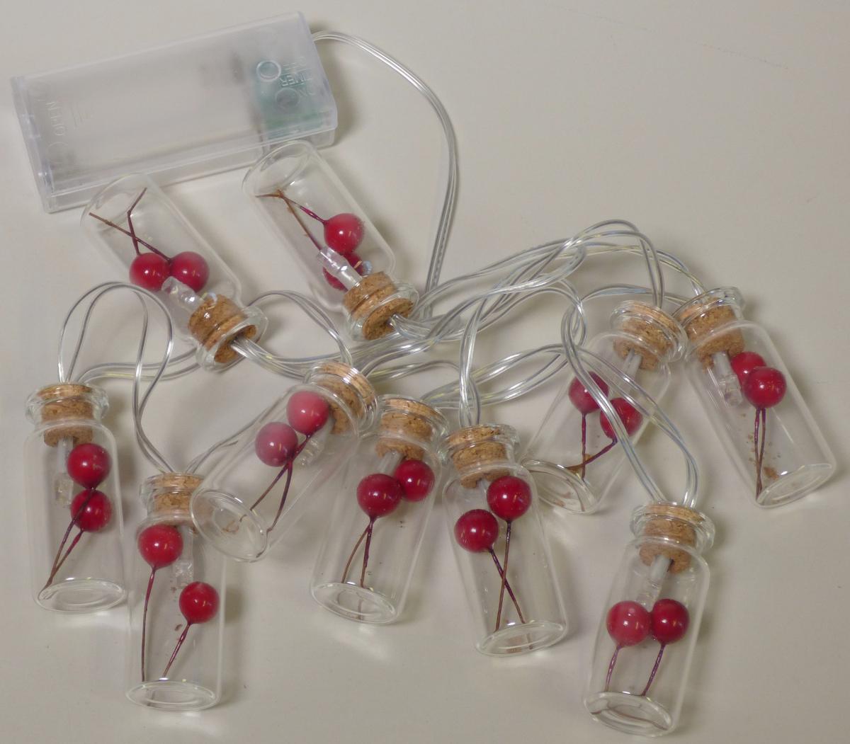 Bei der sog. LED Lichterkette mit Flaschen, Art. 359124 handelt es sich um eine ca. 90 cm lange Lichterkette, bestehend aus einer gedrehten Girlande aus zwei mit farblosem Kunststoff isolierten elektrischen Kabeln mit 10 weißen im Dauerlicht leuchtenden LED-Lichtquellen, die im Abstand von ca. 10 cm angebracht sind.
An jeder Brennstelle ist ein Aufsatz in Form einer ca. 5 cm x 2 cm (L x d) großen Flasche aus farblosem Glas, die mit zwei roten Beeren aus Kunststoff befüllt und mit einem Korkstopfen verschlossen ist, aufgesteckt.
Die Lichterkette ist mit einer ca. 30 cm langen Zuleitung und einem Batteriefach mit Ein-/Ausschalter ausgestattet.

Aufgrund der neutralen Gestaltung handelt es sich um eine Lichterkette, die über das ganze Jahr verwendet werden kann.

Der stoffliche Charakter der Ware wird insbesondere aufgrund des Umfangs durch Glas und Kork bestimmt.

Die Ware ist in einem Karton verpackt.
Hinweise auf Handarbeit liegen nicht vor.

Das Erzeugnis ist als "elektrischer Beleuchtungskörper, anderweit weder genannt noch inbegriffen, nicht von den Unterpositionen (HS) 9405 11 bis 9405 41 erfasst, ausschließlich zur Verwendung mit LED-Lichtquellen bestimmt, kein Scheinwerfer, aus Glas und Kork, nicht handgearbeitet" einzureihen.
