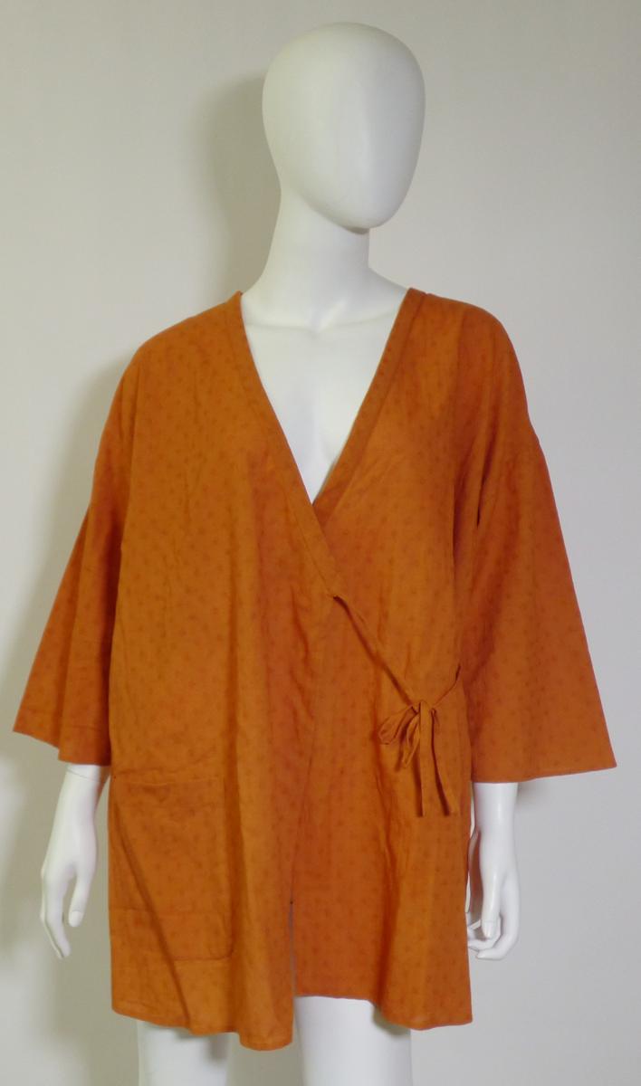 Jacke, sog. Kimono, Größe M, Foto siehe Anlage,
- aus ca. 0,2 mm dicken, einfarbigen, musterbildend gewebten Geweben aus laut Antrag Baumwolle,
- über den Schritt reichend (Rückenlänge: ca. 79 cm),
- im Wickelstil gearbeitet, vorn mit einer durchgehenden Öffnung, die mit insgesamt vier angenähten
  Bindebändern von rechts über links überlappend (Frauenkleidung) geschlossen werden kann,
- mit ca. 3/4-langen Ärmeln,
- vorn mit einer aufgesetzten, offenen Tasche unterhalb der Taille (somit keine Ware der Position 6206),
- am unteren Rand durch Umschlagen und Festnähen gesäumt,
- keine Arbeits- und Berufskleidung.

"Jacke, aus Geweben, für Frauen, aus Baumwolle, keine Arbeits- und Berufskleidung, nicht nach dem
 Batik-Verfahren handbedruckt"
