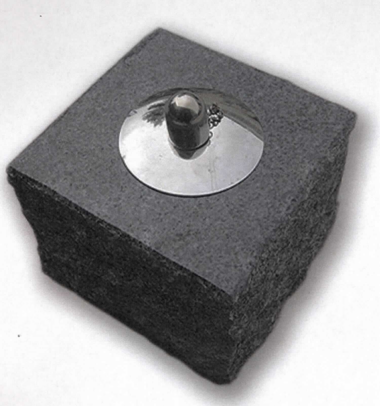 Bei der sog. Öllampe "CARUSO", Art-Nr. FO21137490 handelt es sich um einen nicht elektrischen Beleuchtungskörper in Form einer Öllampe, bestehend aus einem Metallbehälter für Ölbefüllung mit Spinnstoffdocht und einem Metalldeckel, welcher in ein annähernd würfelförmiges, ca. 12 cm x 12 cm x 10,5 cm (L x B x H) großes Gehäuse aus Granit (lt. AStin handgearbeitete Steinmetzarbeit) eingehängt ist.

Das Erzeugnis dient zu Beleuchtungszwecken.

Die Ware ist als "nicht elektrischer Beleuchtungskörper, anderweit weder genannt noch inbegriffen, handgearbeitet" einzureihen.